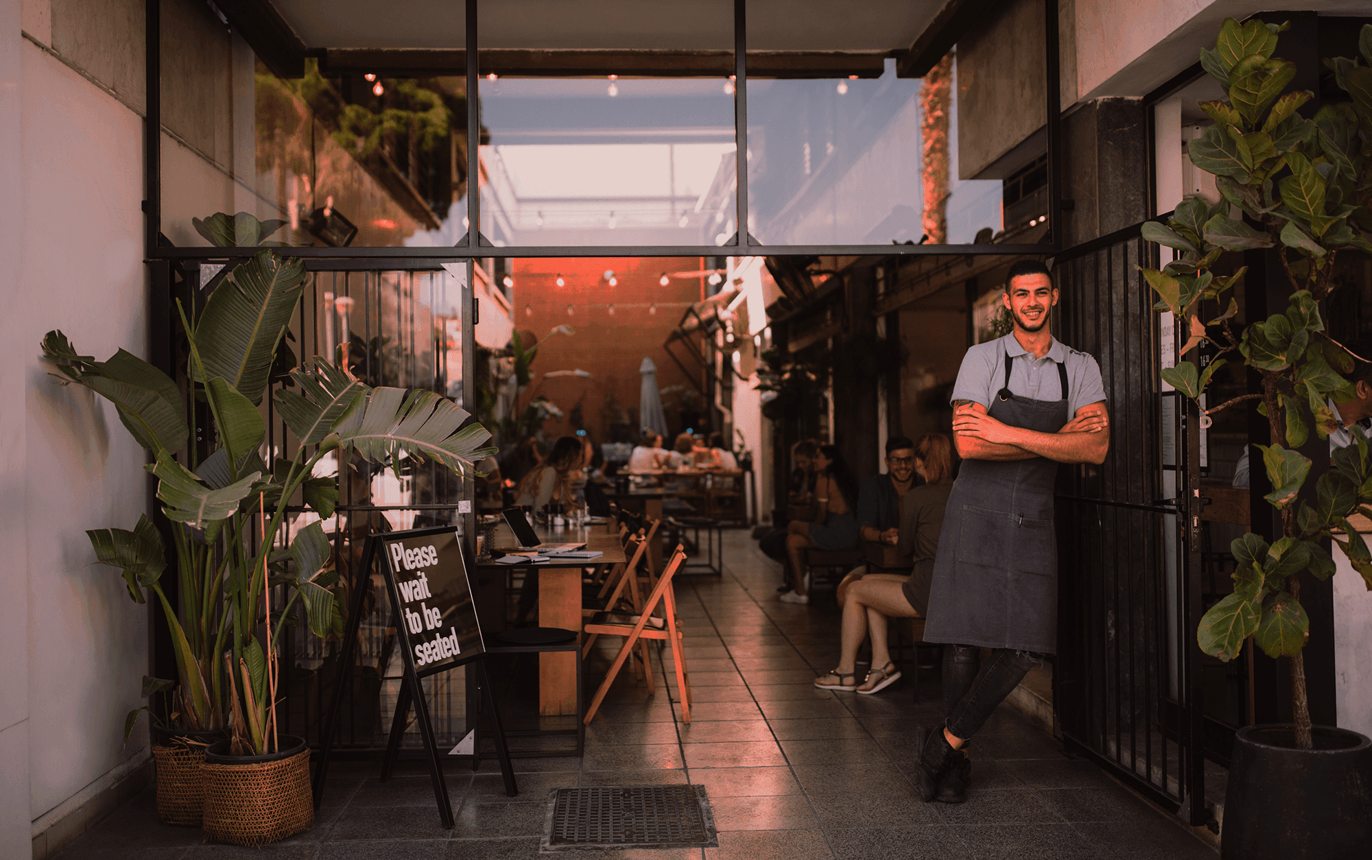 Restaurant owner standing in front of a restaurant - POS pricing - Shift4 Dine