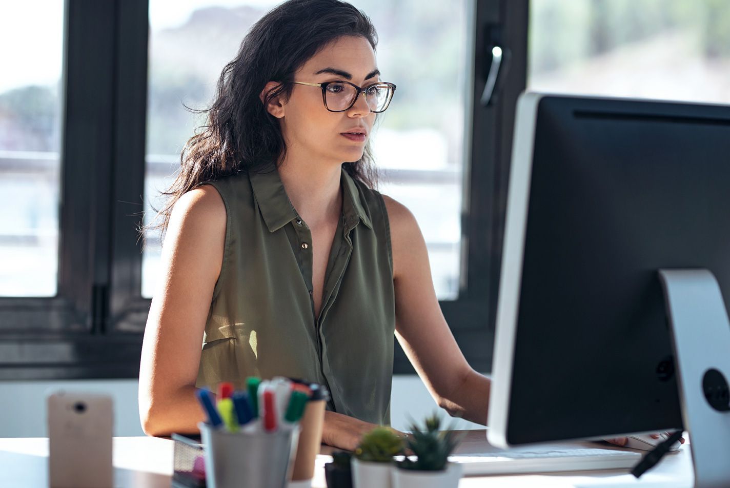 Woman using a desktop computer - restaurant labor management - Shift4 Dine