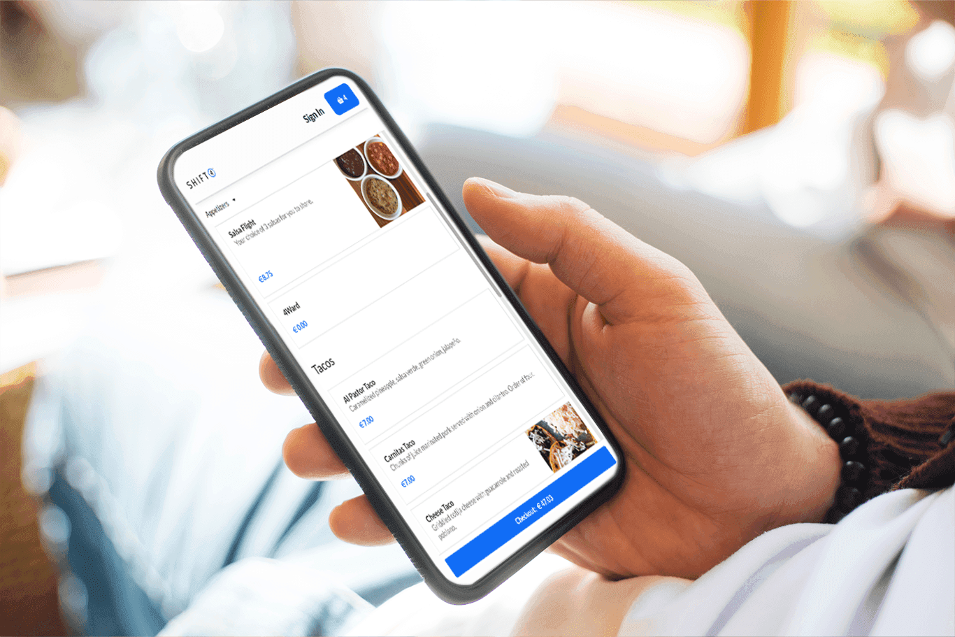 A hand holding a smartphone showing a online ordering menu for a restaurant on the screen - enterprise POS system - Shift4 Dine