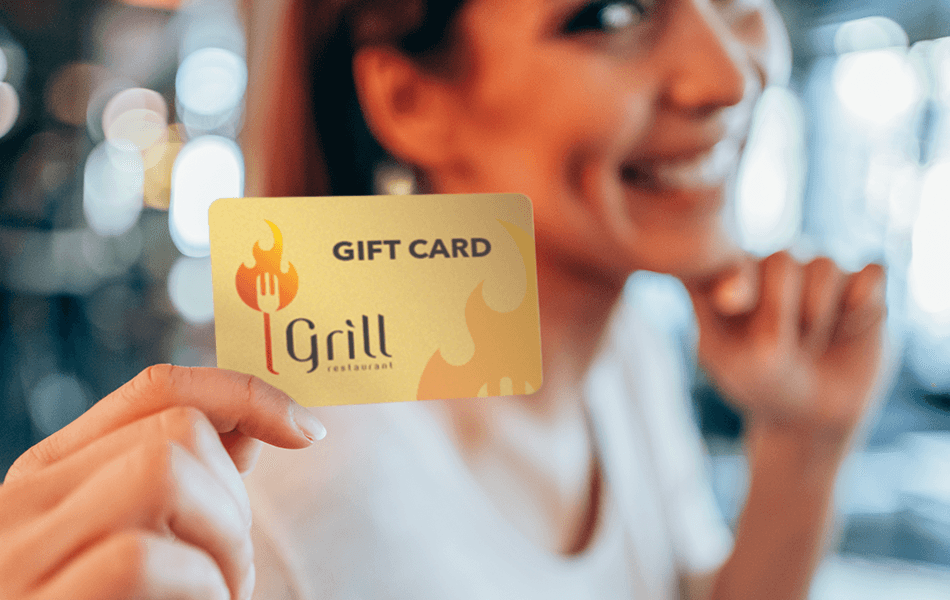 Smiling person holding up a gift card - loyalty and marketing - Shift4 Dine