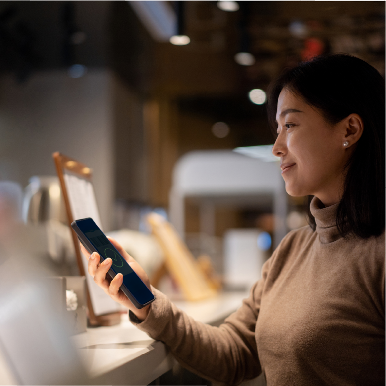 Woman using her smartphone to pay with crypto - crypto POS system - Shift4 Dine