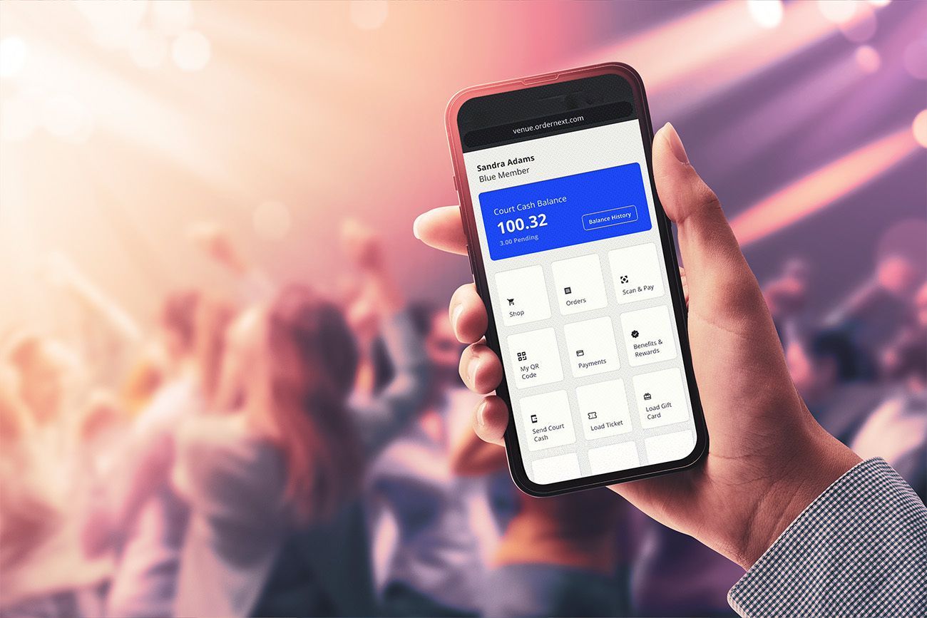 Close up of an entertainment venue customer holding up a smartphone showing an order-from-seat feature - venue POS system - Shift4