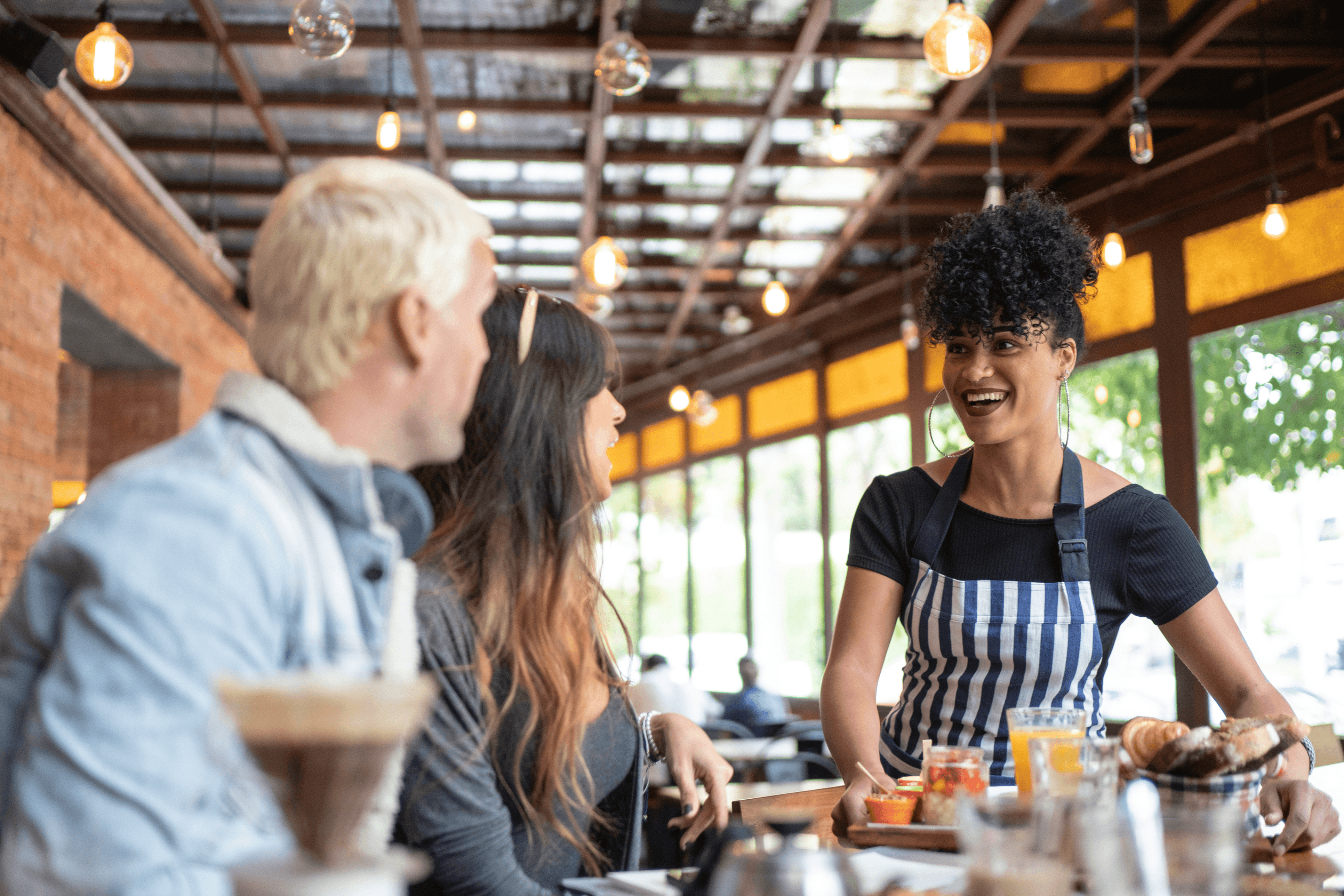 Restaurant employee talking to customers - restaurant reporting and analytics - Shift4 Dine