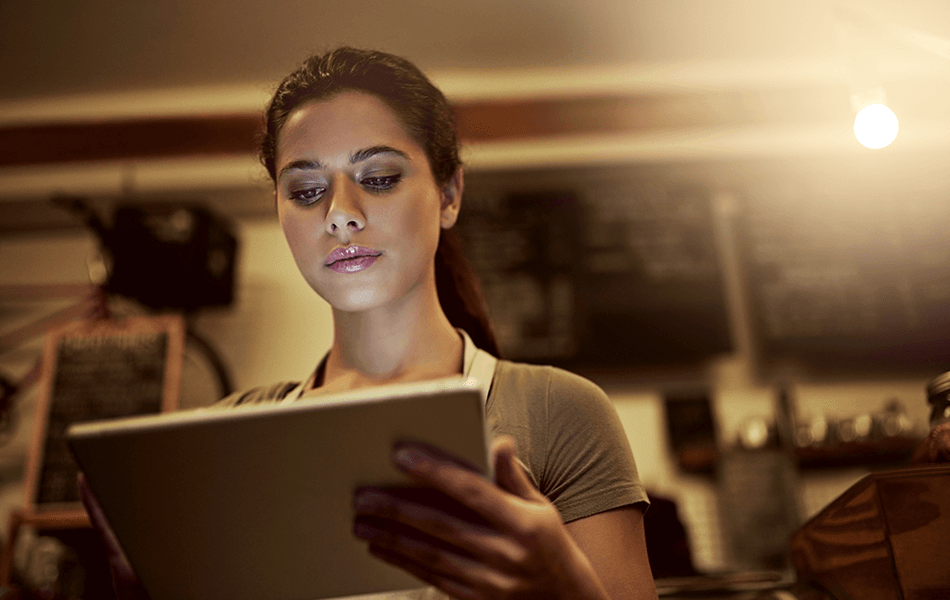 Restaurant employee looking at a tablet - loyalty and marketing - Shift4 Dine