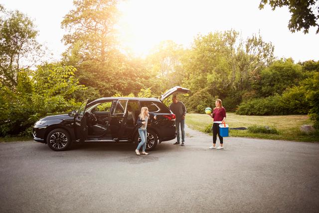 Billede af en familie, der er ved at stige ud af bilen på vej til en tur i parken.
