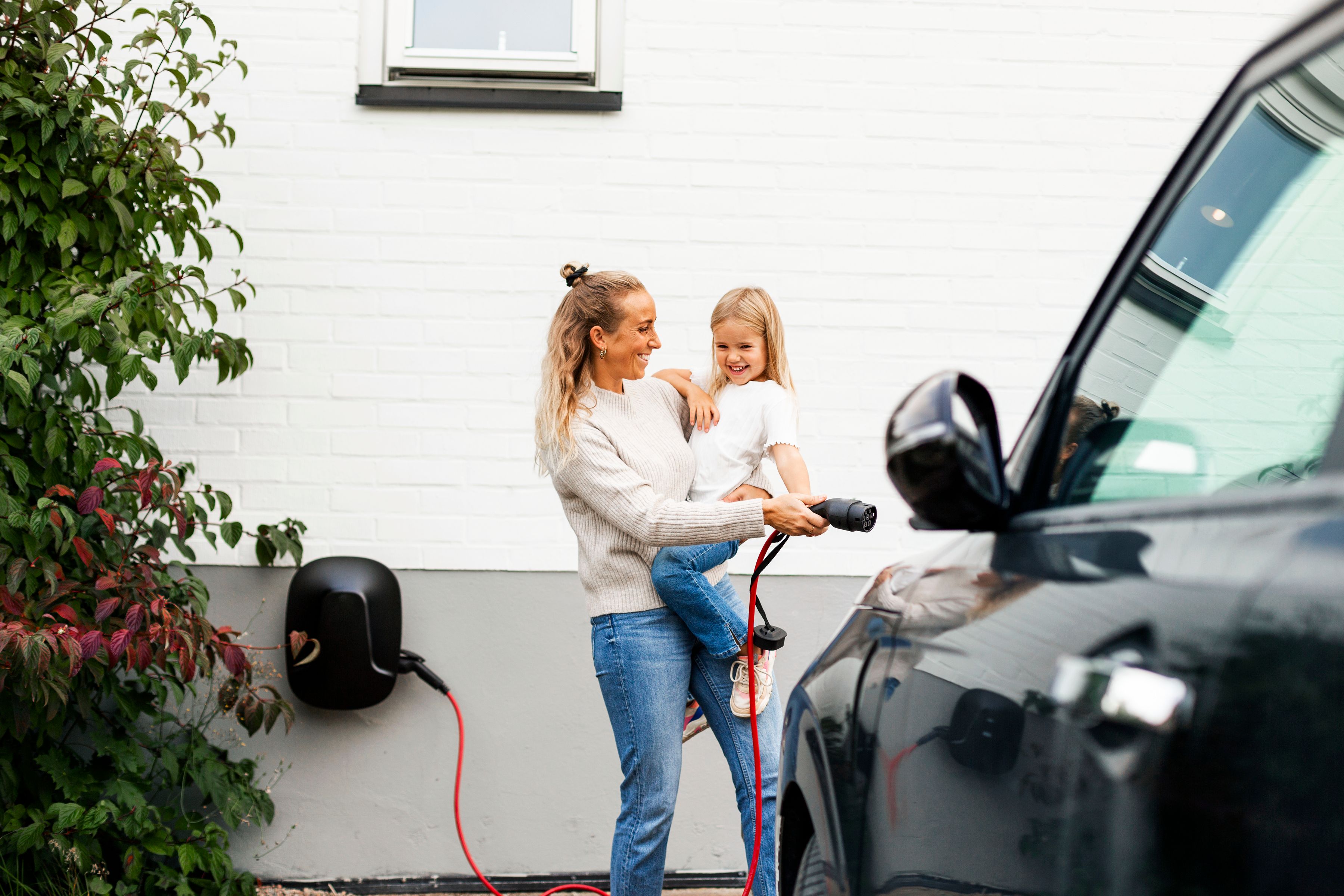 Foto af kvinde, der oplader elbil i ejerforening