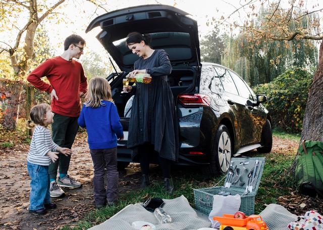 Foto af en familie på picnic med deres elbil.