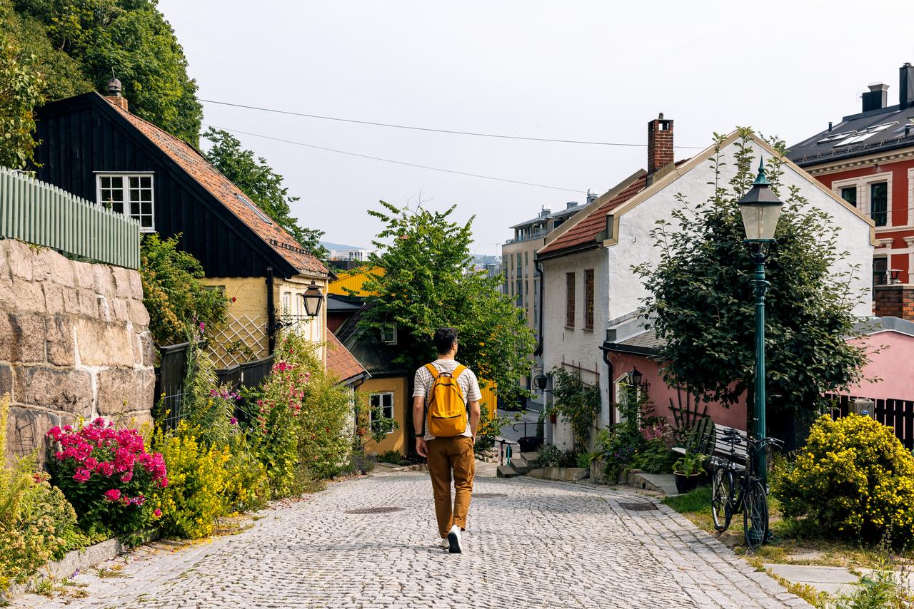 Billede af en mand, der går på en gade mellem farverige huse