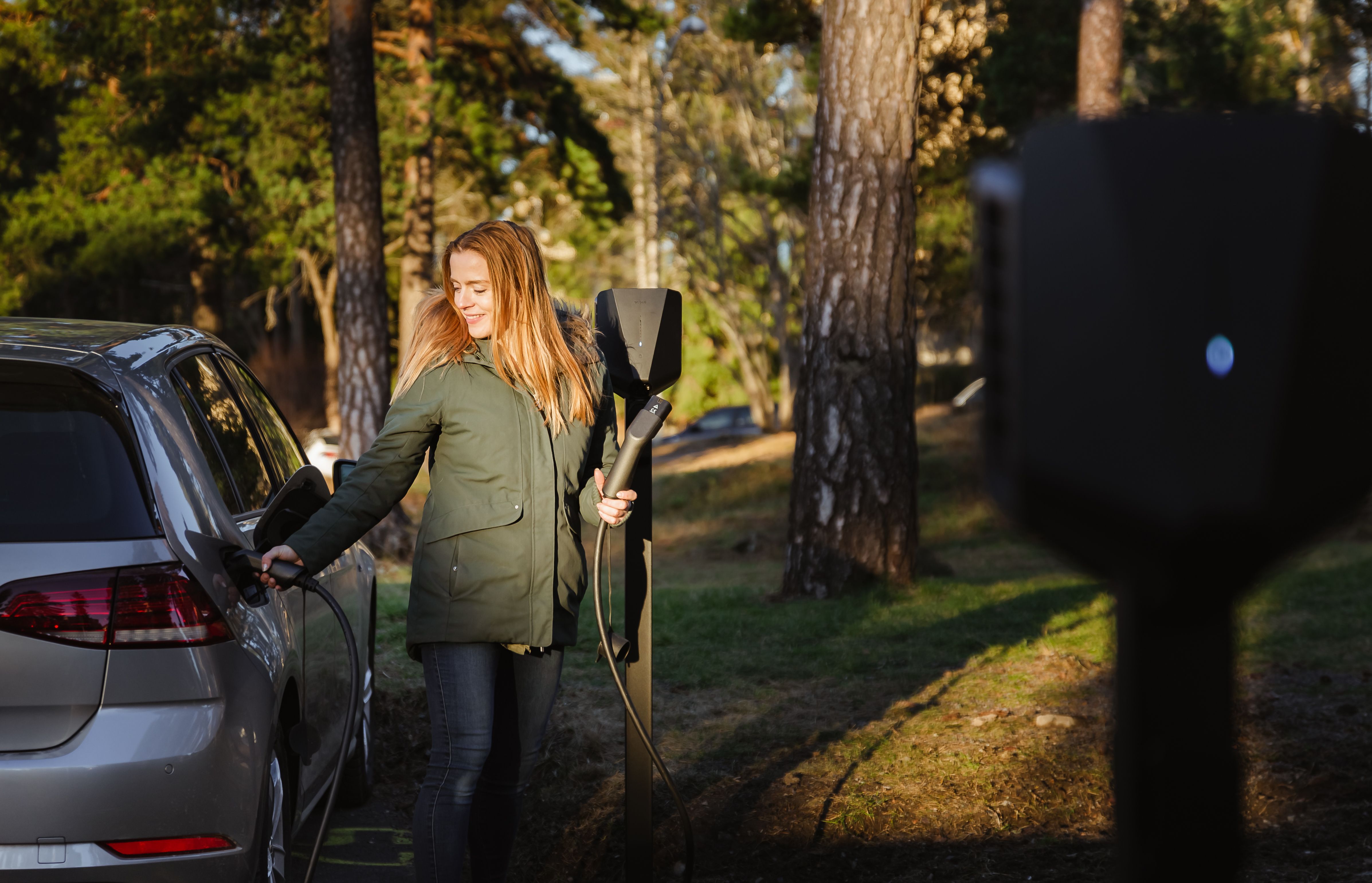 En kvinde, der oplader sin bil.