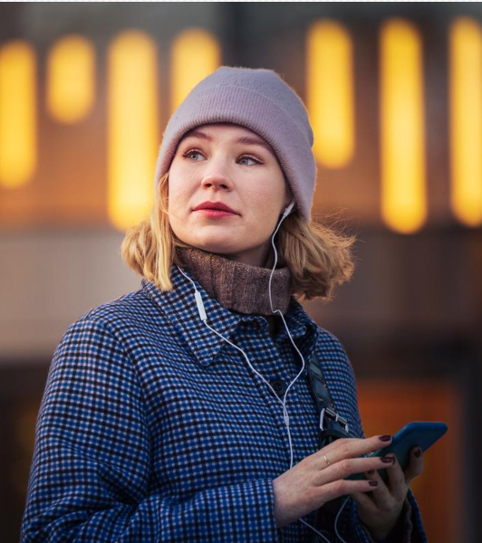 Foto af en kvinde i vintertøj med en mobiltelefon.