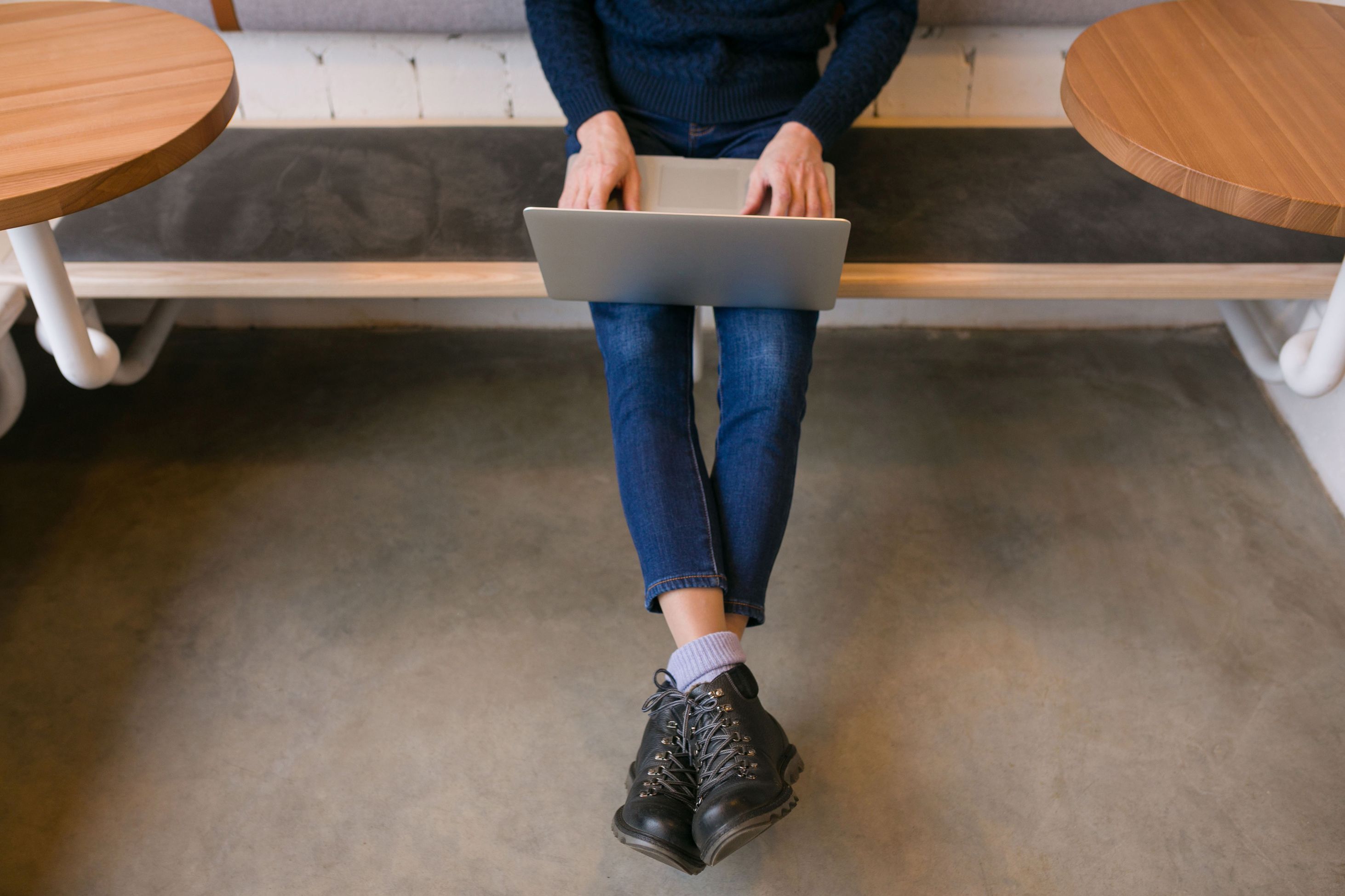 A person's torso and legs with a laptop on their lap