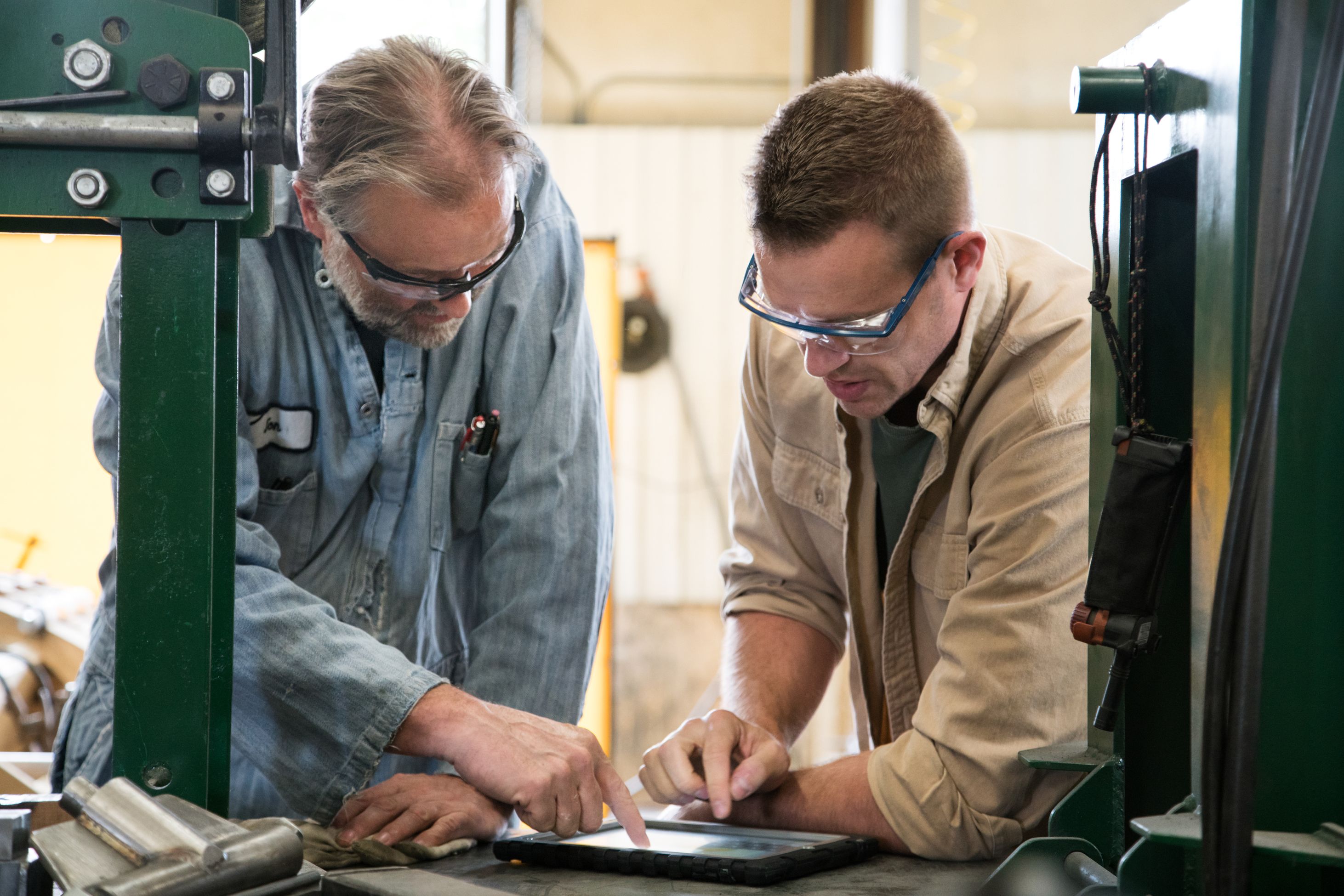 Two men working on tablet in a warehouse