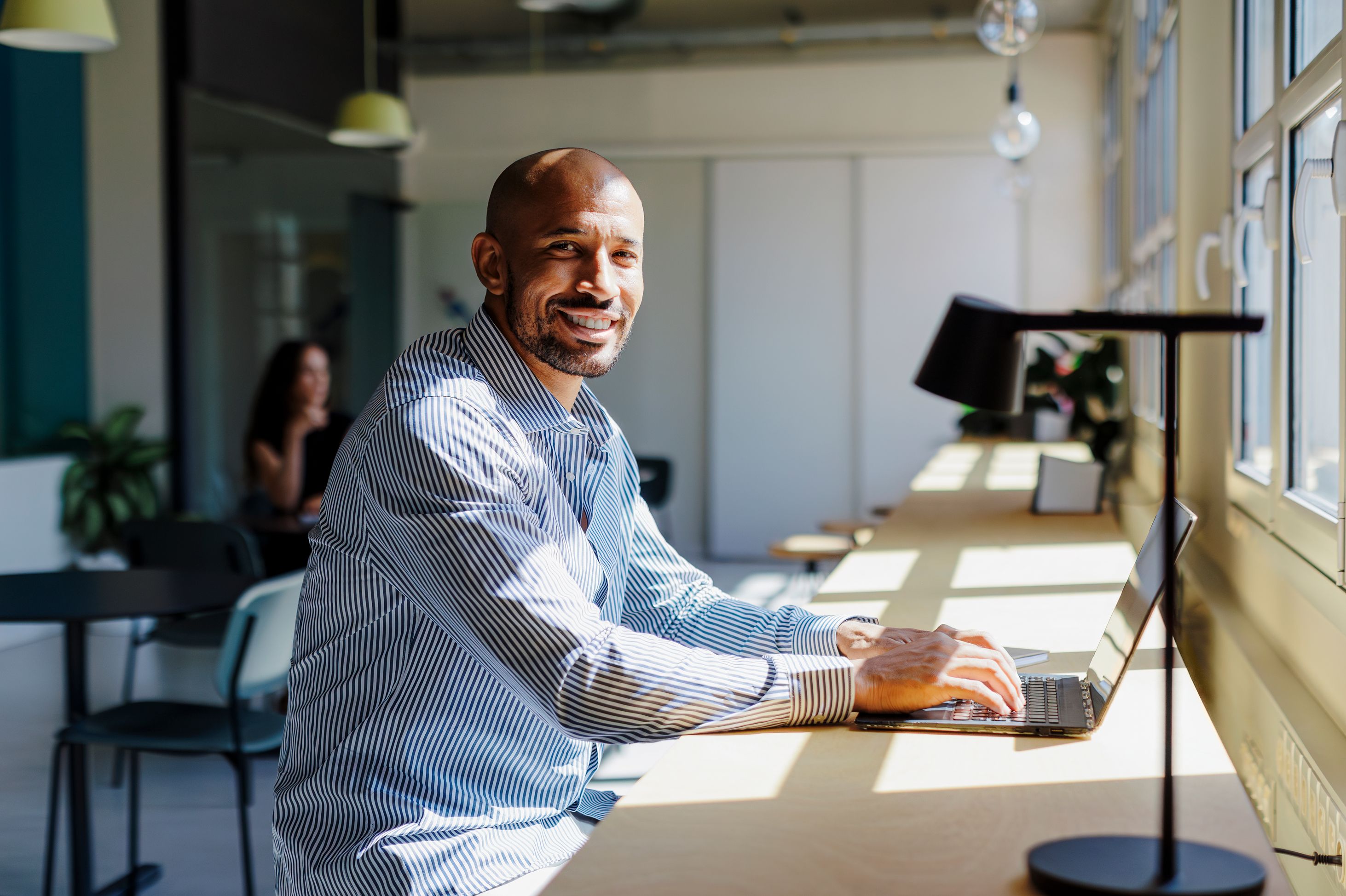 Man typing on laptop facing camera