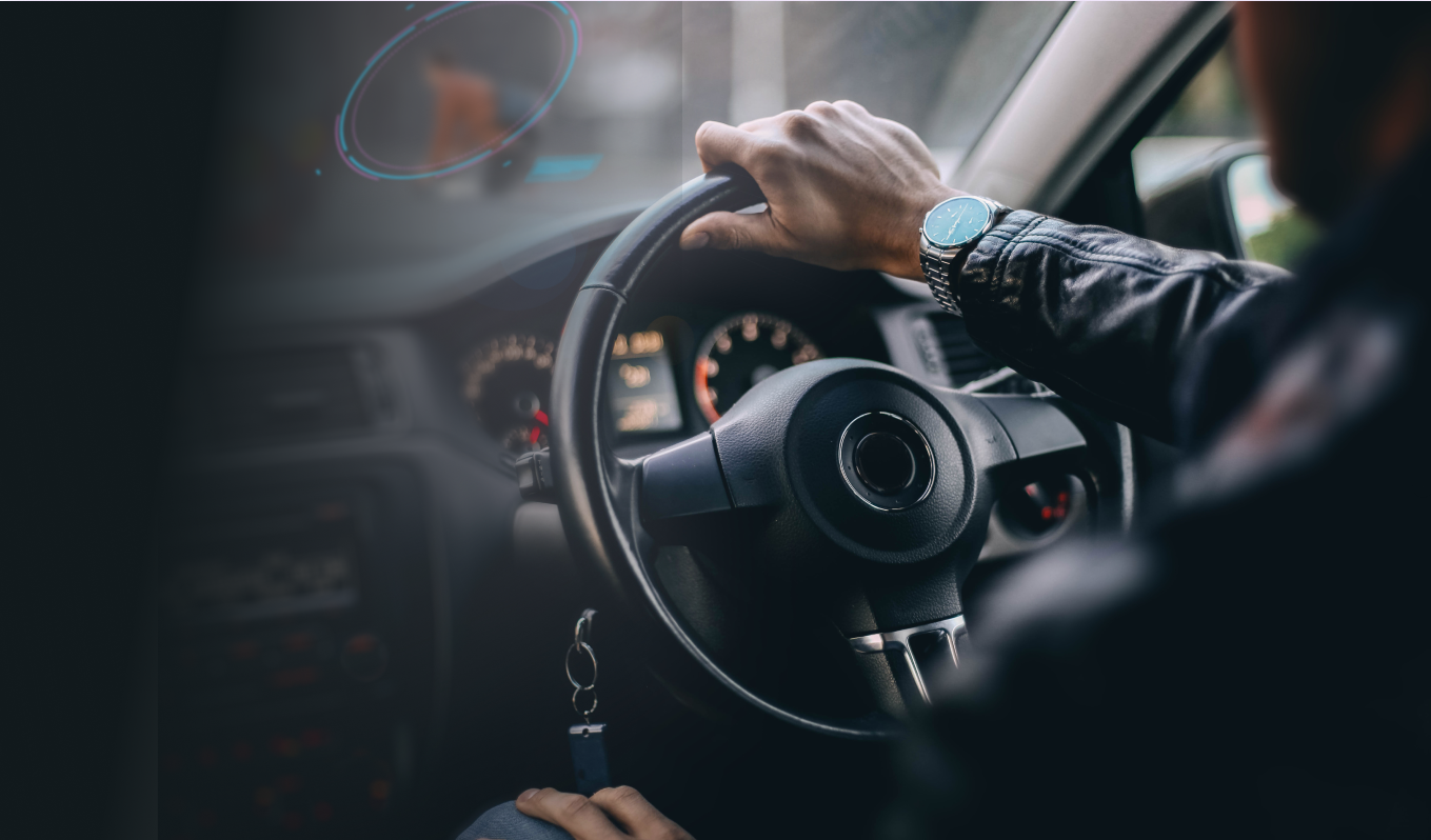 Person sitting in car with hands on the wheel