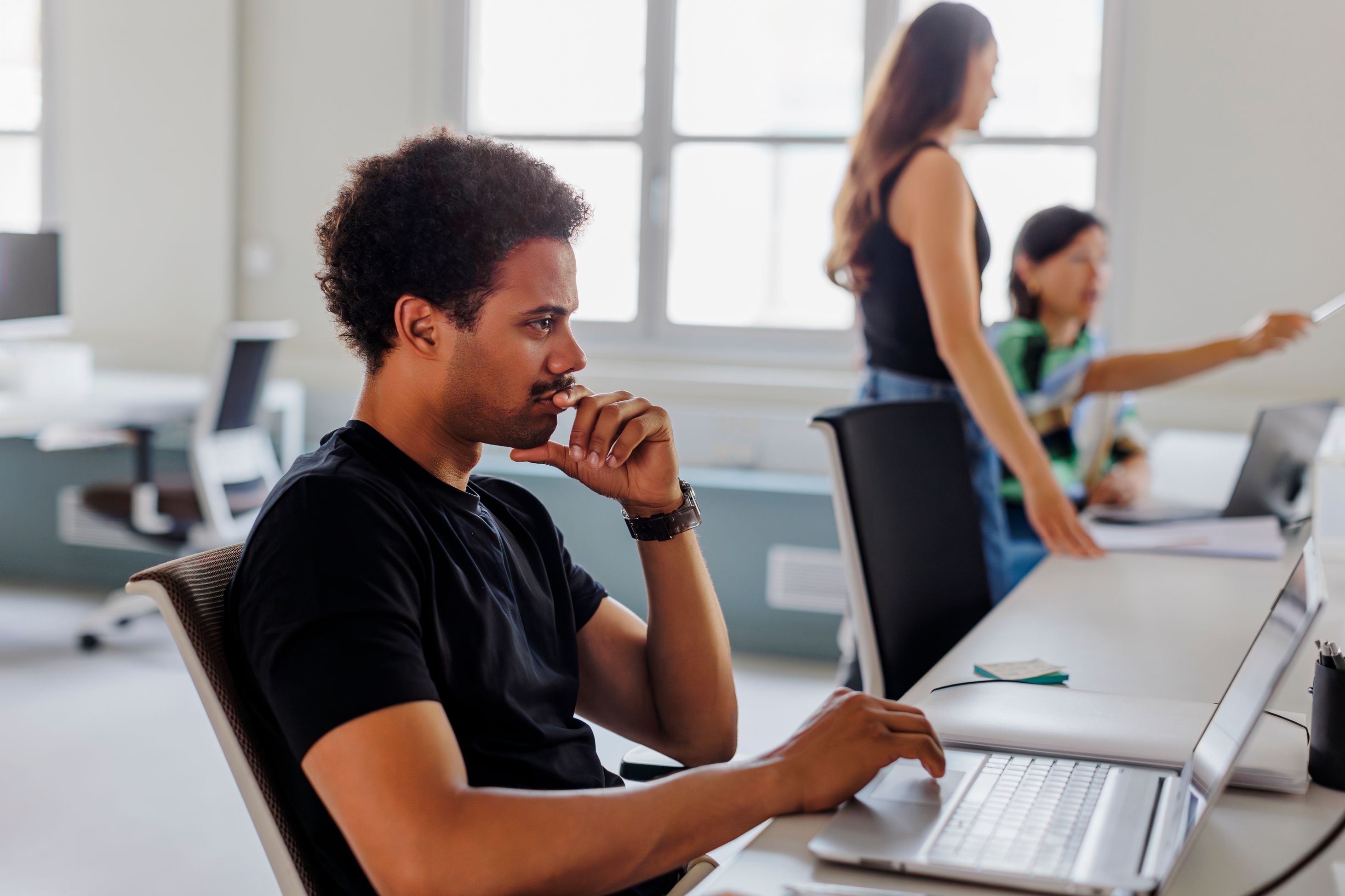 man sitting in front of his laptop thinking
