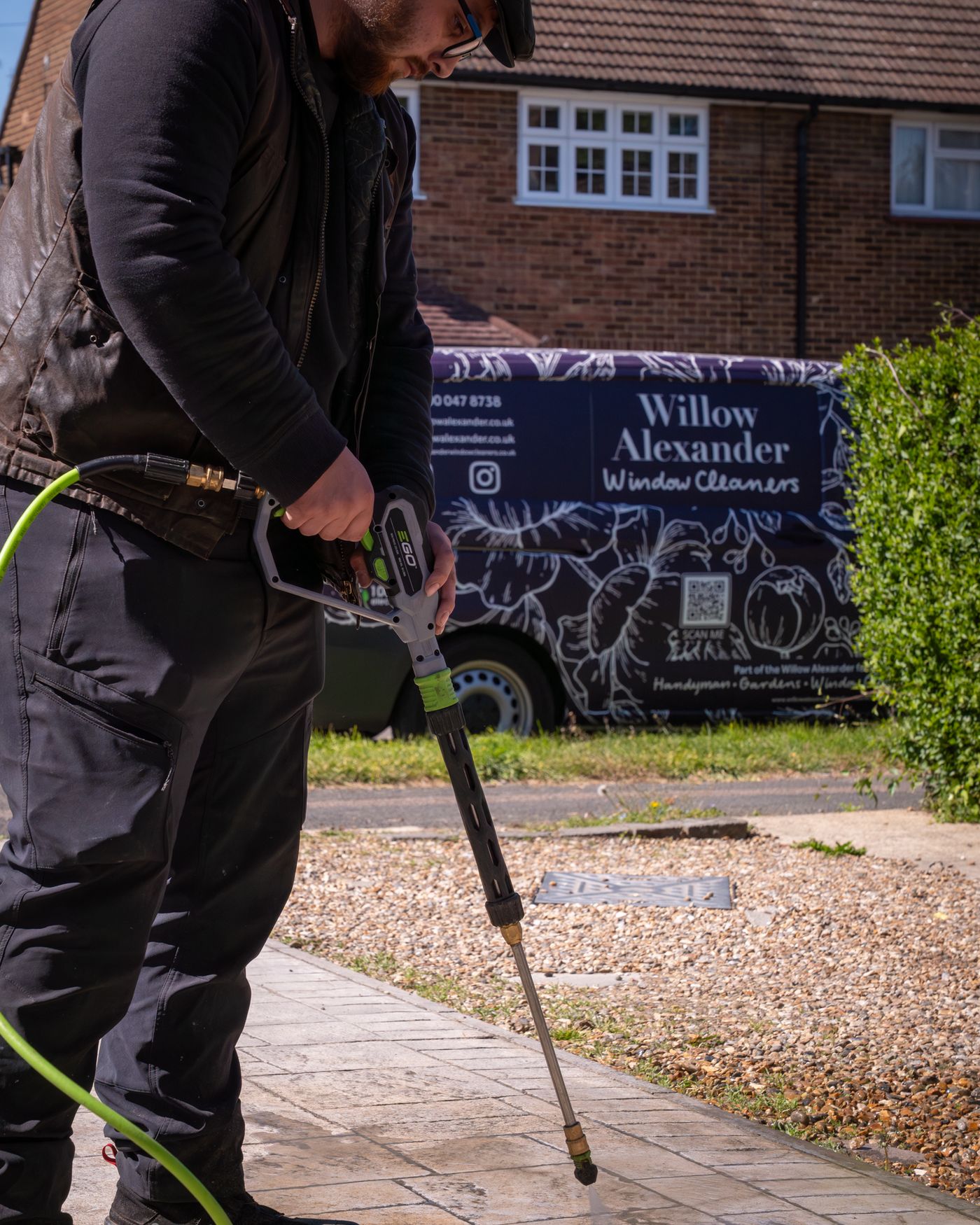A freshly jet washed driveway in front of a well-kept home, with clean paving joints, clear windows and clipped planting framing the entrance