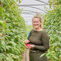 Willemien met een hand vol frambozen.