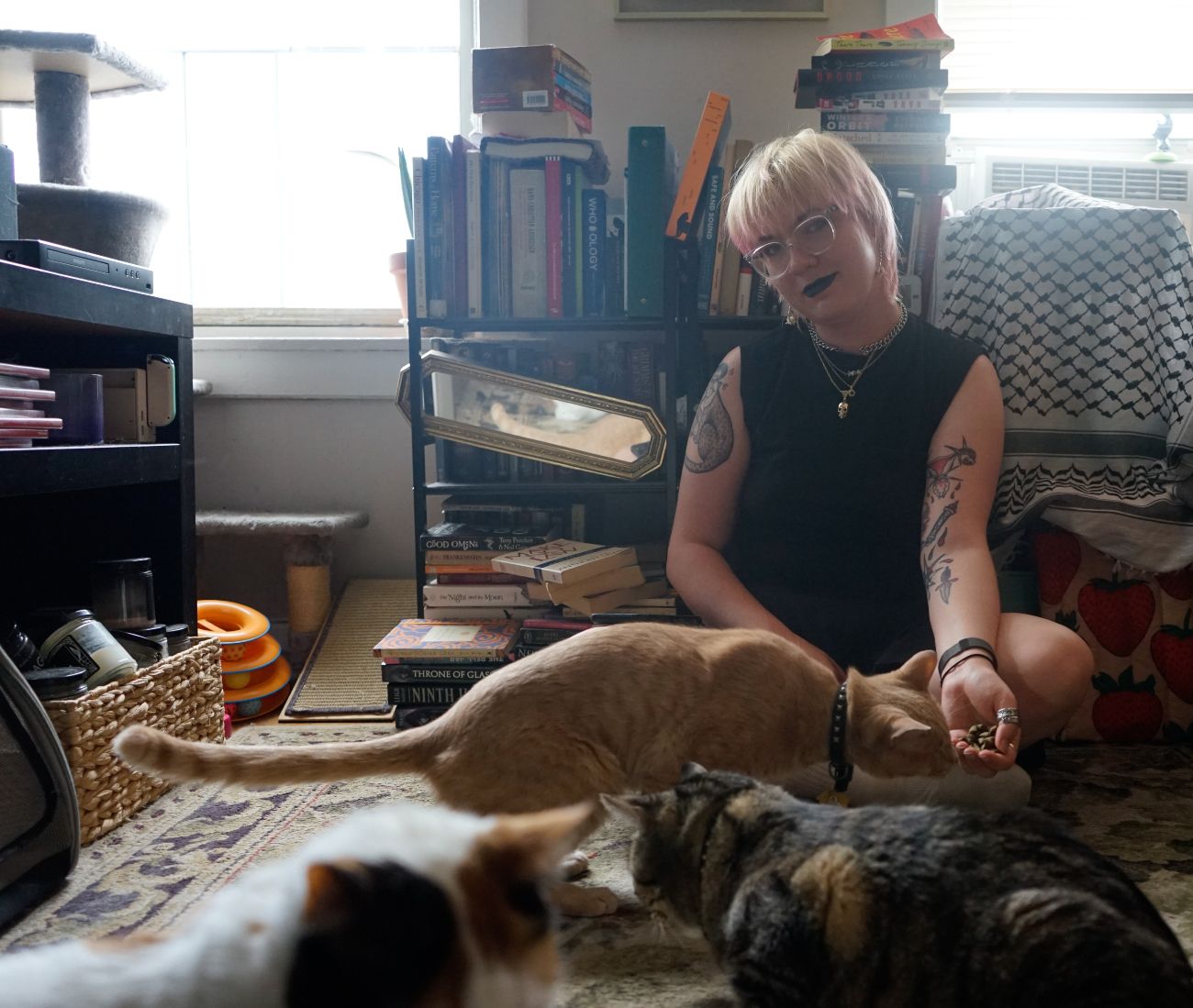 Abbey can be seen here with some of their favorite things, her three cats (Sylas, Sherman and Toblerone) and books.