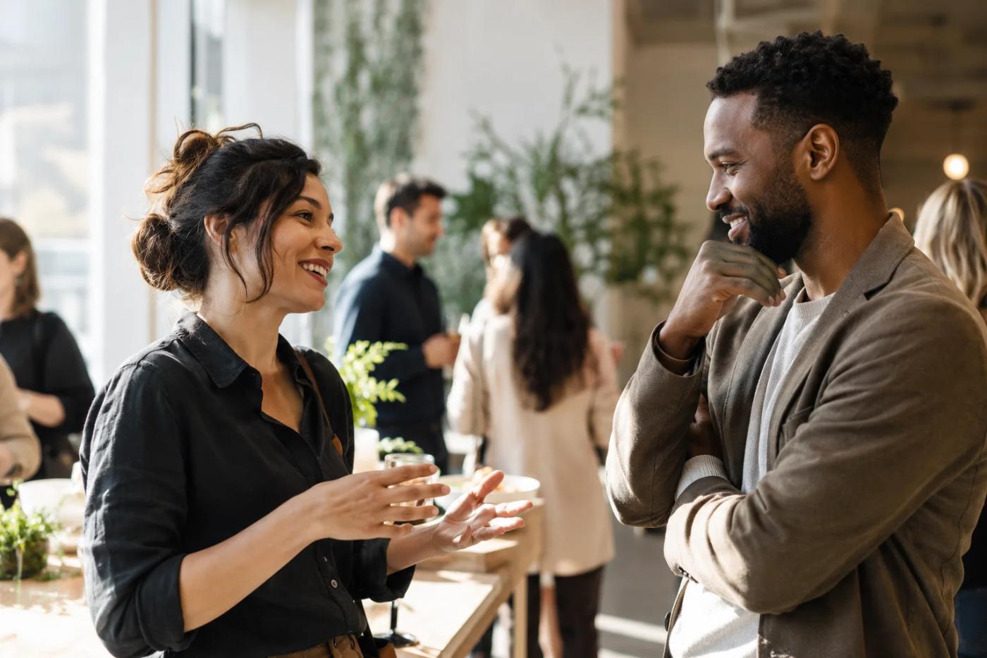 Two professionals talking at an illustrative networking event.