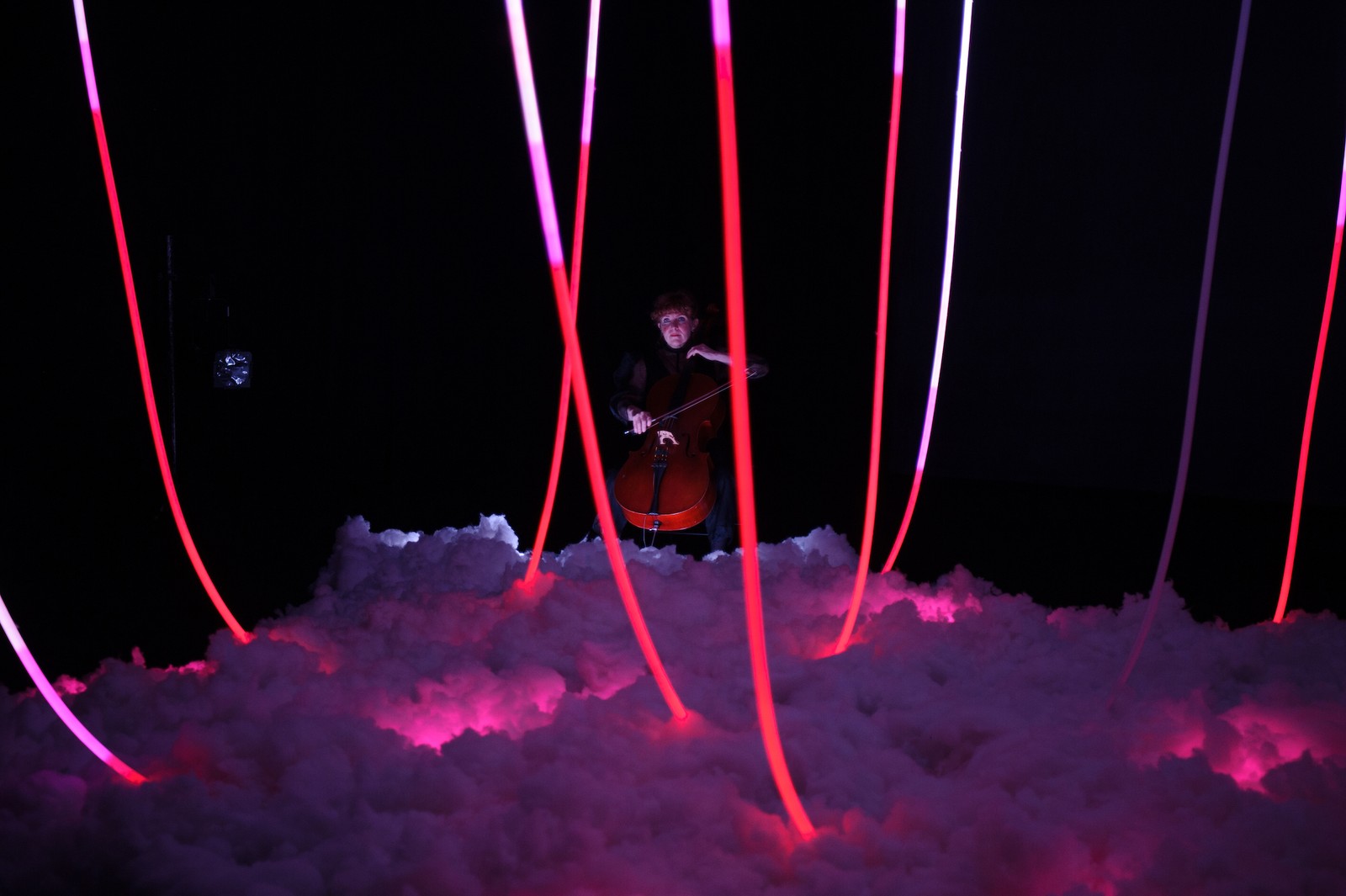 A woman bows a cello in a dark space as part of The Nervous Atmosphere by Zoe Barry and Chamber Made