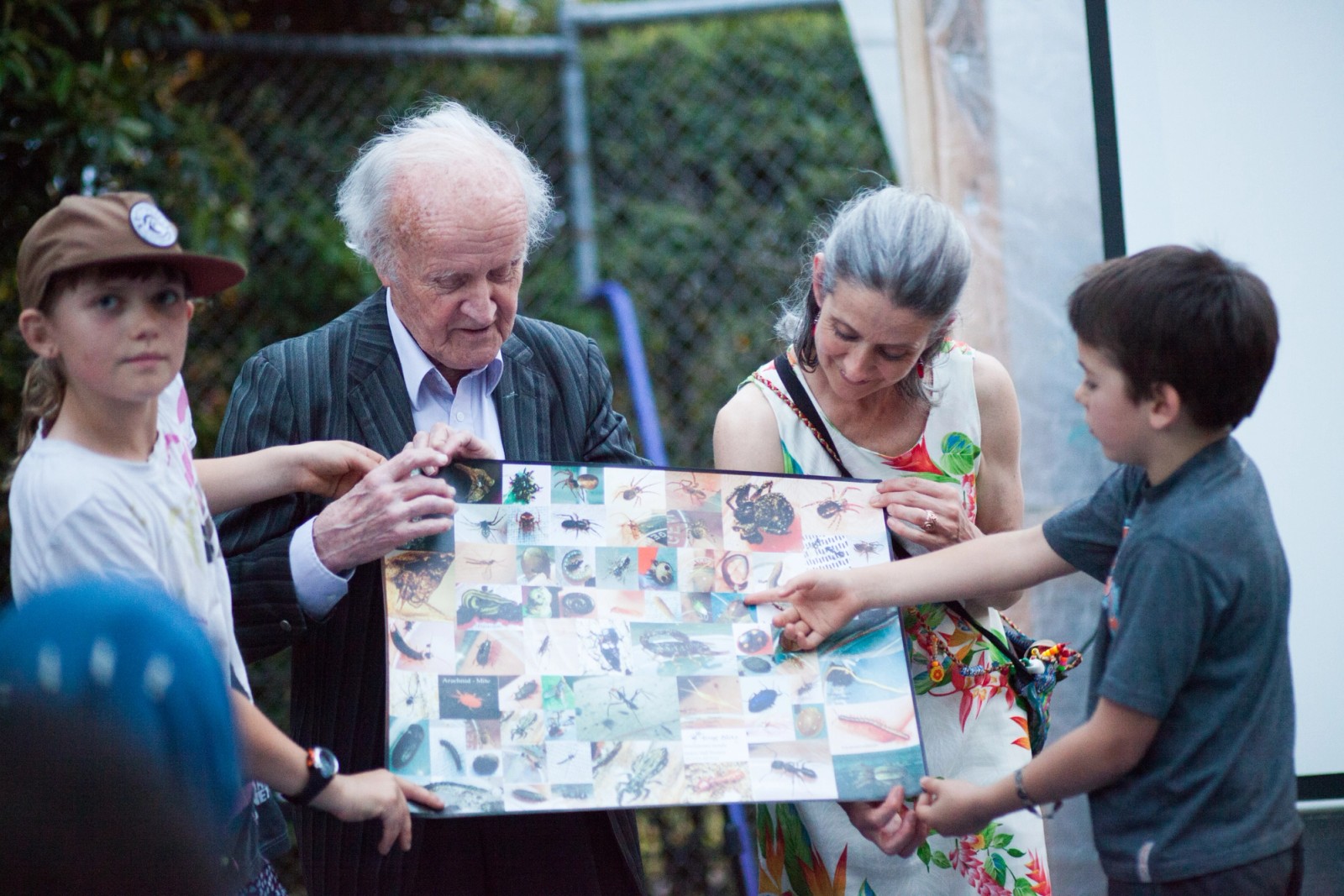 A woman and older man look at a visual chart presented by two children as part of The Chamber Made Venny Celebration 2018