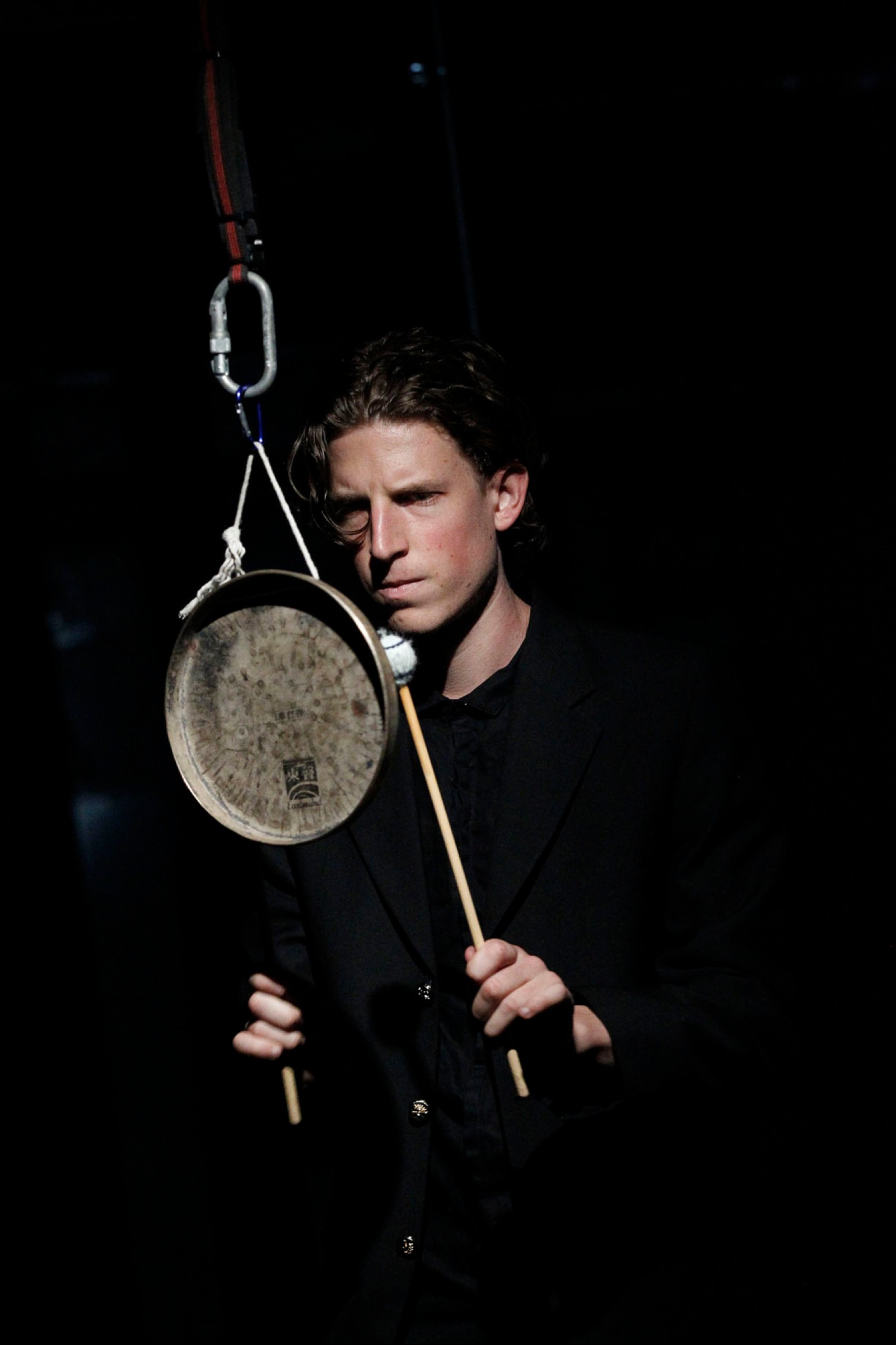 A man strikes a suspended gong as part of Captives of the City by Chamber Made