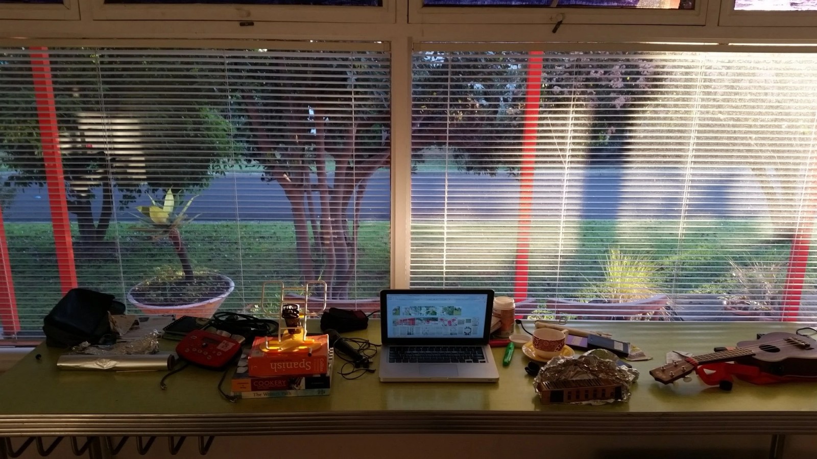 A long table in front of a window with many items from Orange Residency by Carolyn Connors