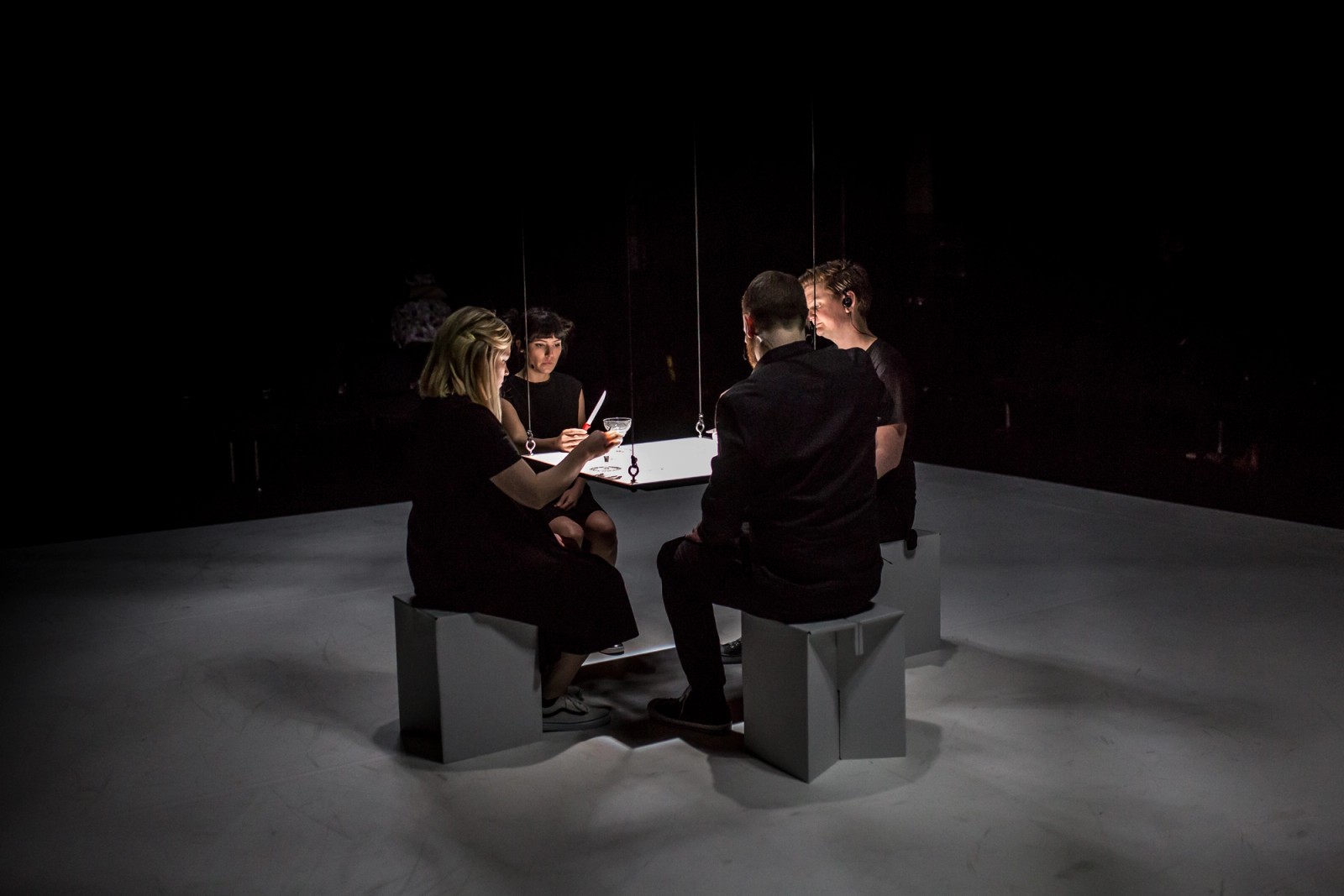 Four performers sit around a square table as part of Permission to Speak by Chamber Made