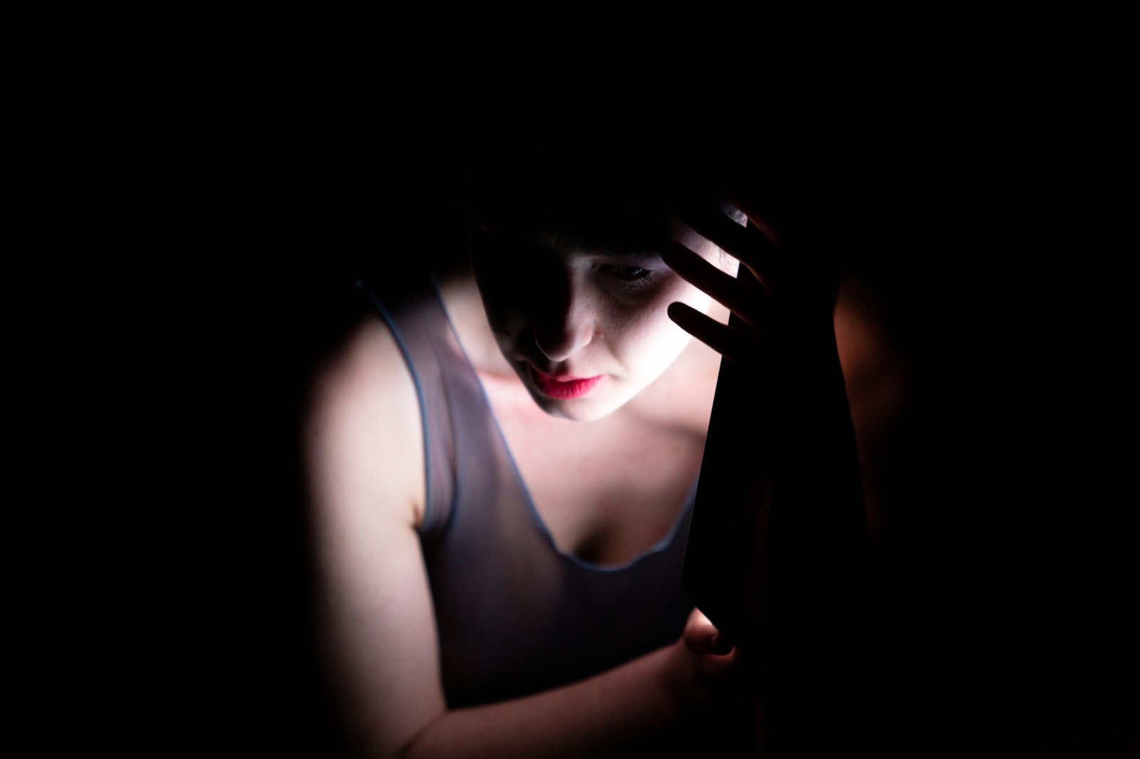 Woman's face side lit by light of screen