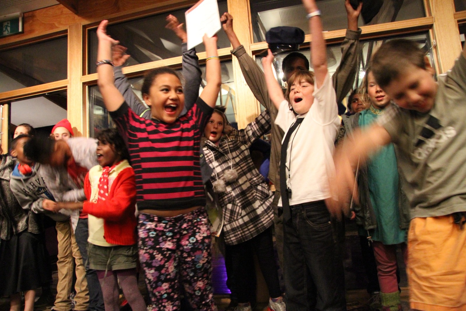 A large group of children celebrating with arms raised as part of Chamber Made's The Venny Project 2012-2014