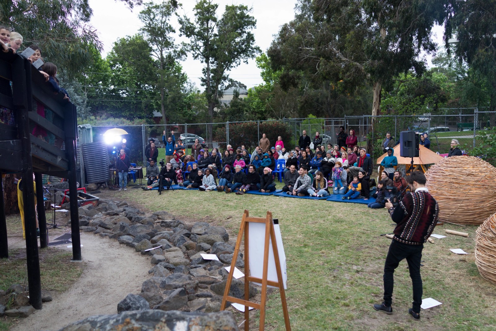 A large audience watches a performance at a playground as part of Chamber Made's The Venny Imagine a Place 2017