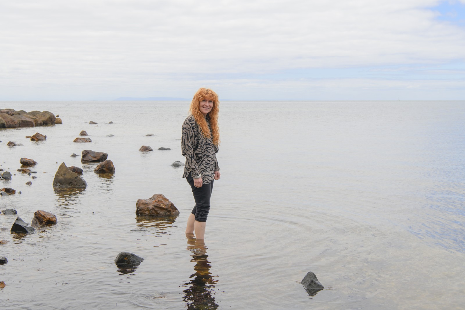 Zoe standing in ankle deep water in the bay