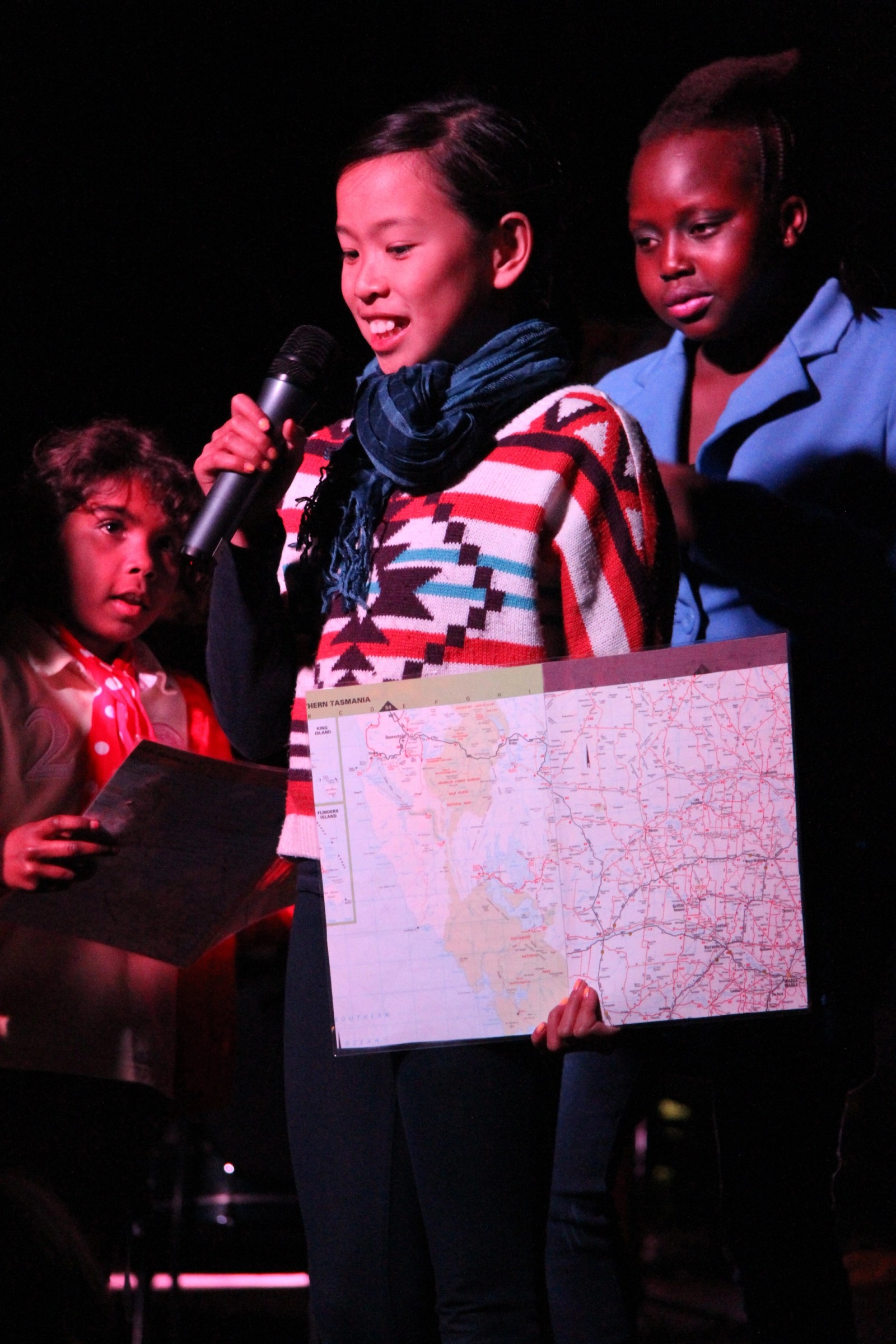 Three children performing with a microphone and map as part of Chamber Made's The Venny Project 2012-2014