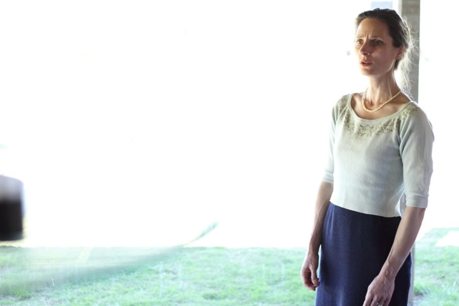 A woman against a washed out window performing as part of Turbulence by Chamber Made