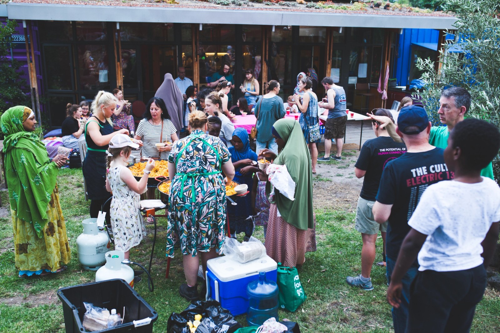 A large group of people sharing food at an outdoor gathering as part of The Chamber Made Venny Celebration 2018