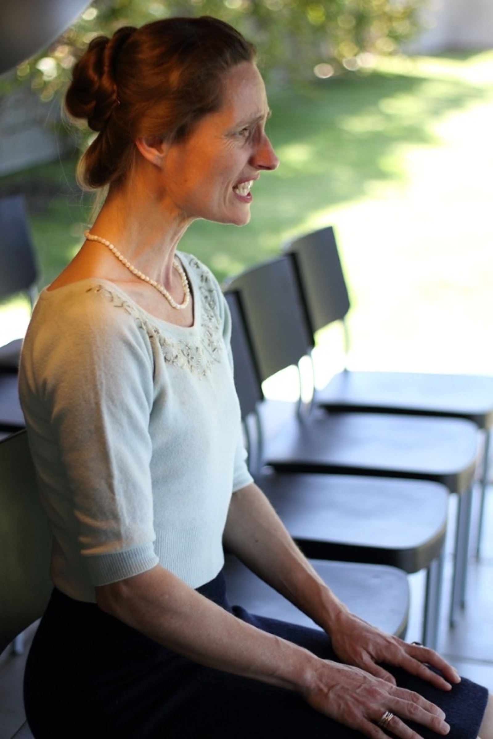A woman sings while sitting within a row of seats as part of Turbulence by Chamber Made