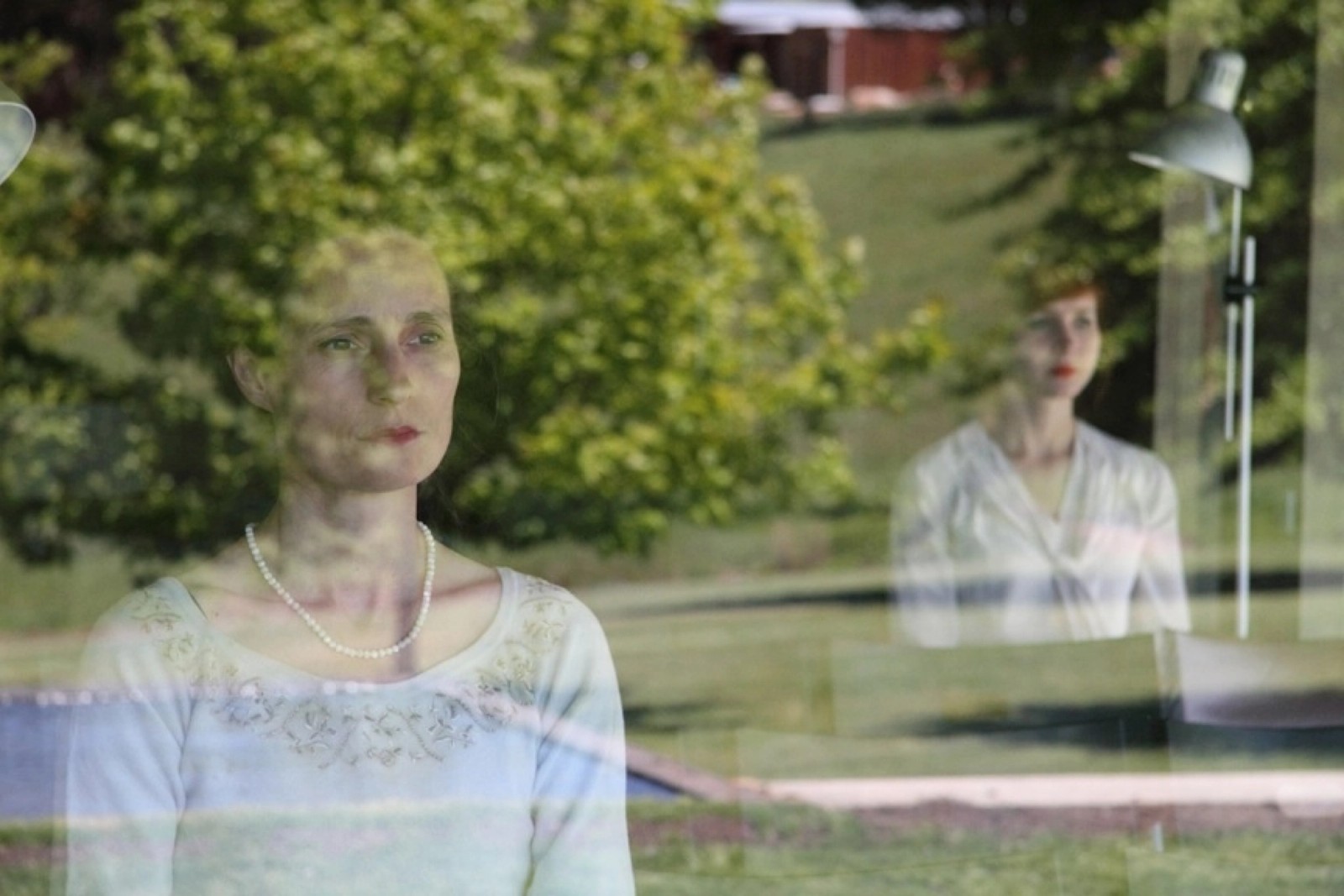 Two women reflected in a window with a garden visible as part of Turbulence by Chamber Made