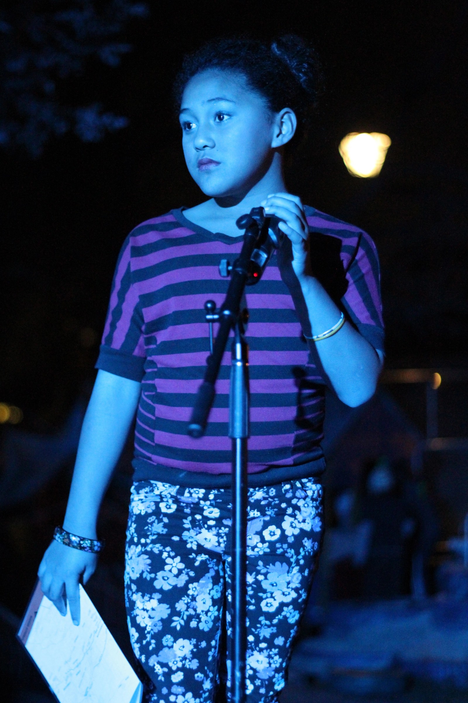 A young girl at a microphone at night as part of Chamber Made's The Venny Project 2012-2014