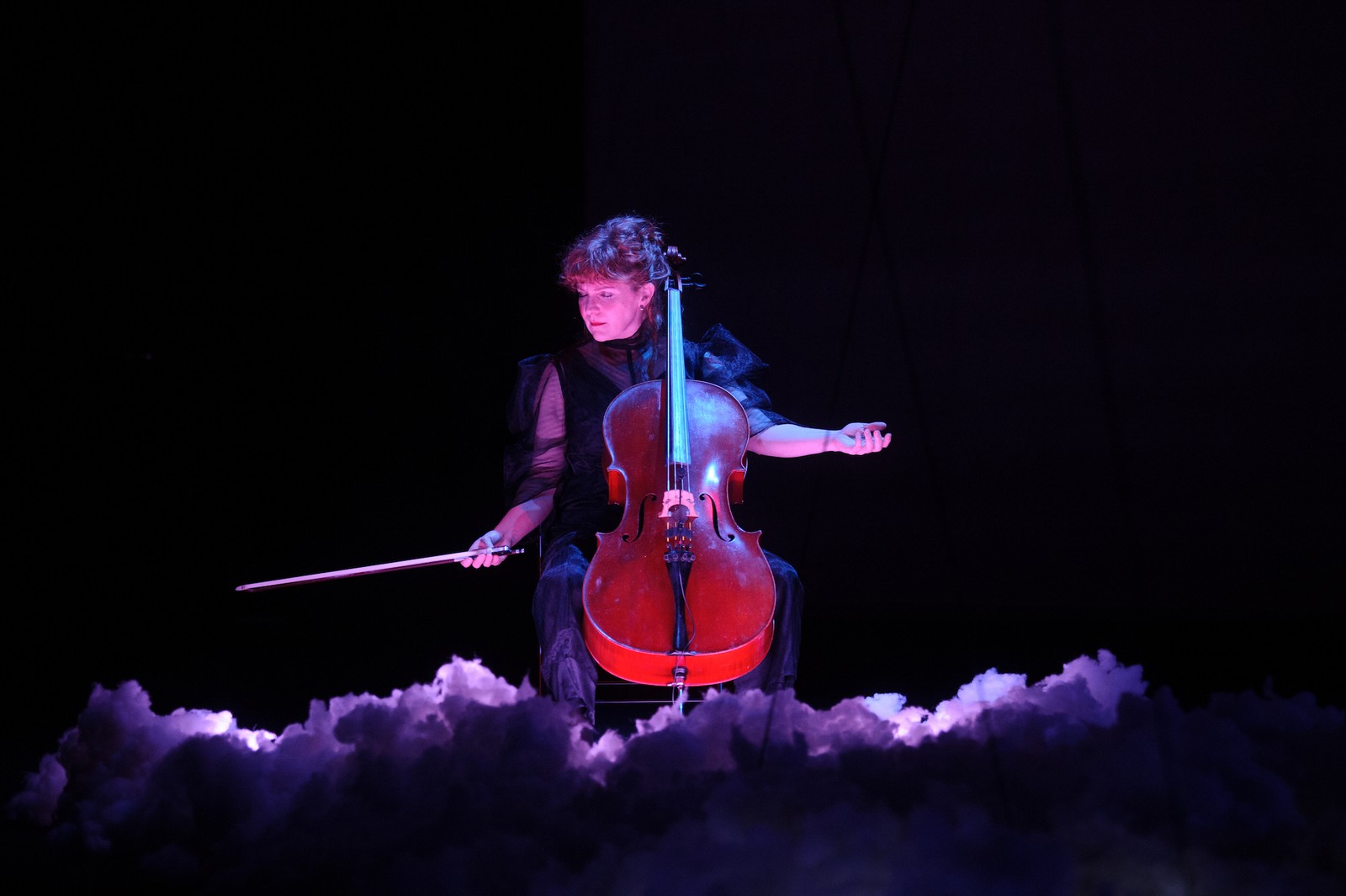 In a darkened space a woman plays a cello as part of The Nervous Atmosphere by Zoe Barry and Chamber Made