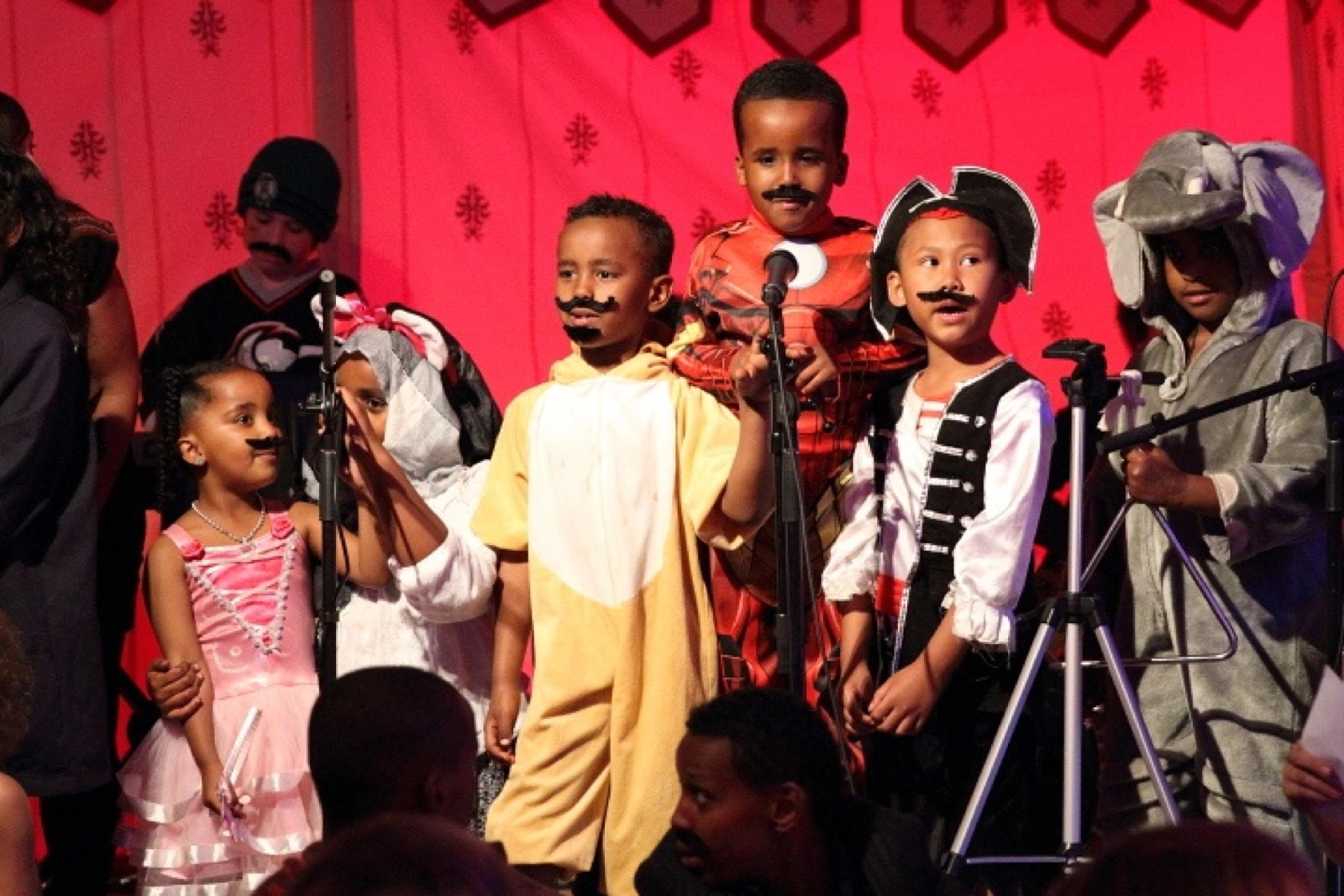 Children performing all wearing costumes and false moustaches as part of Chamber Made's The Venny Project 2012-2014