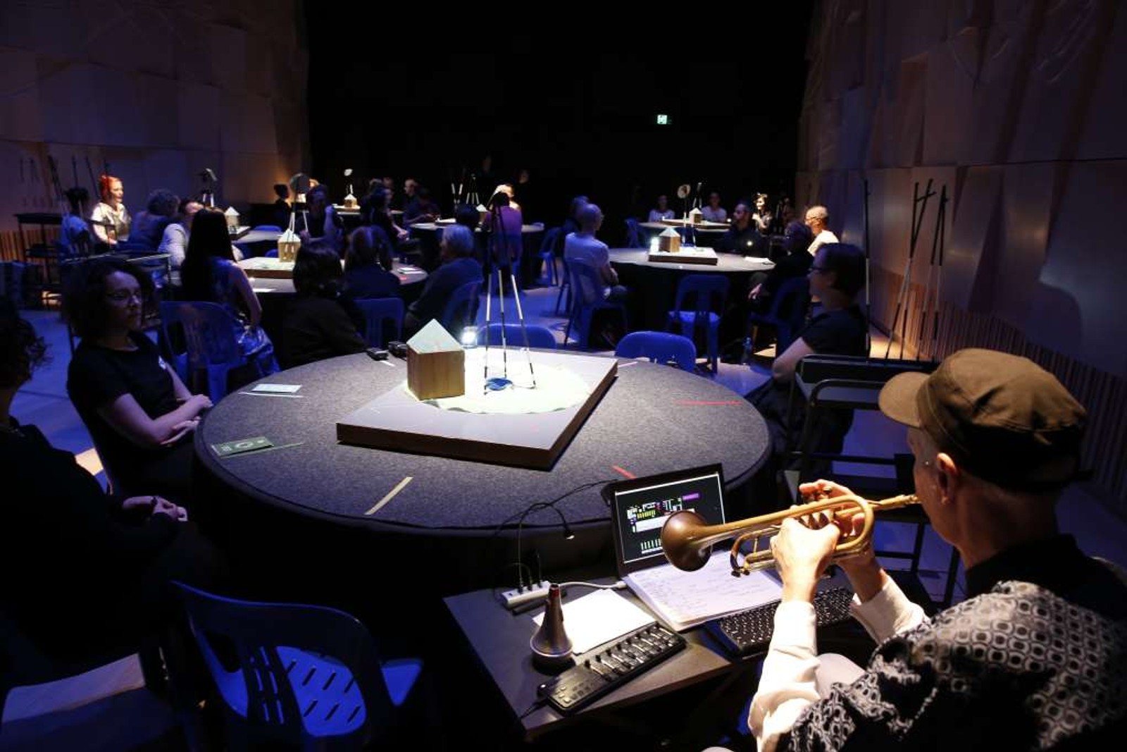 People gathered at round tables, some performers and some audience as part of Between 8 and 9 by Chamber Made at Melbourne Recital Centre