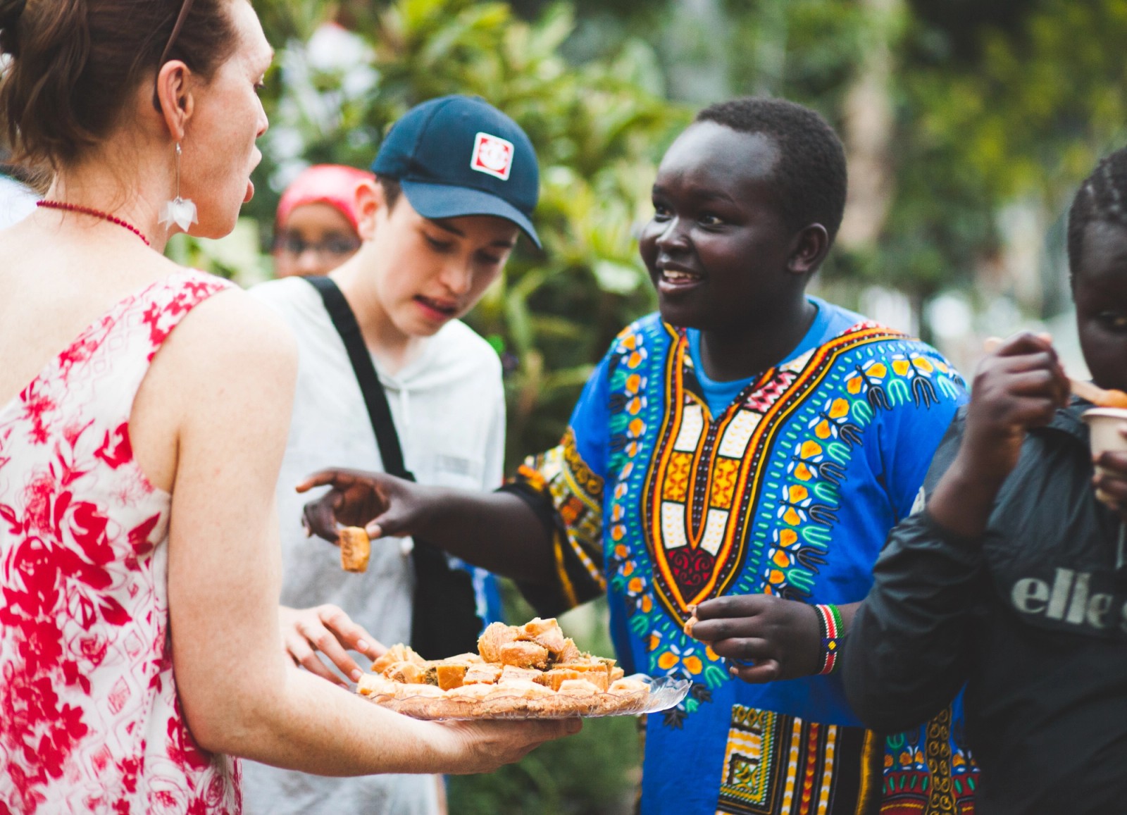 A woman offers food to young people as part of The Chamber Made Venny Celebration 2018