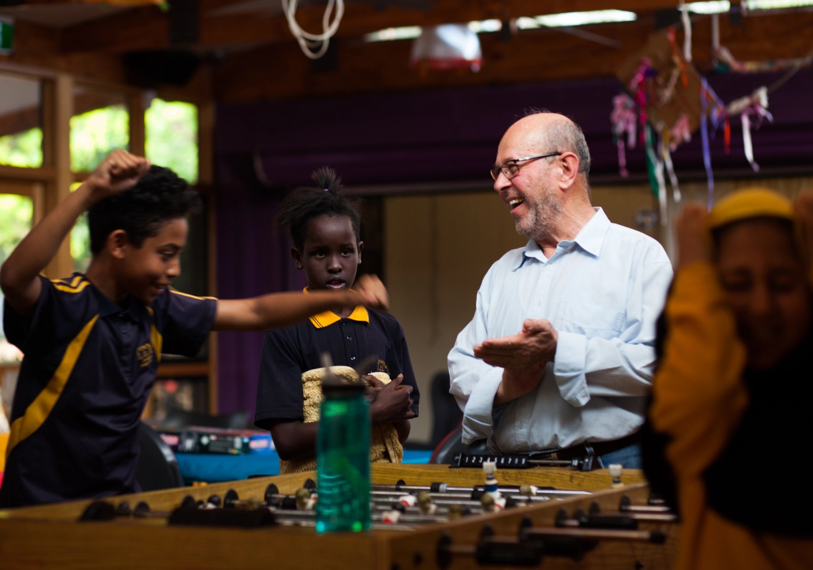 A man and three children play a table top board game as part of The Chamber Made Venny Celebration 2018