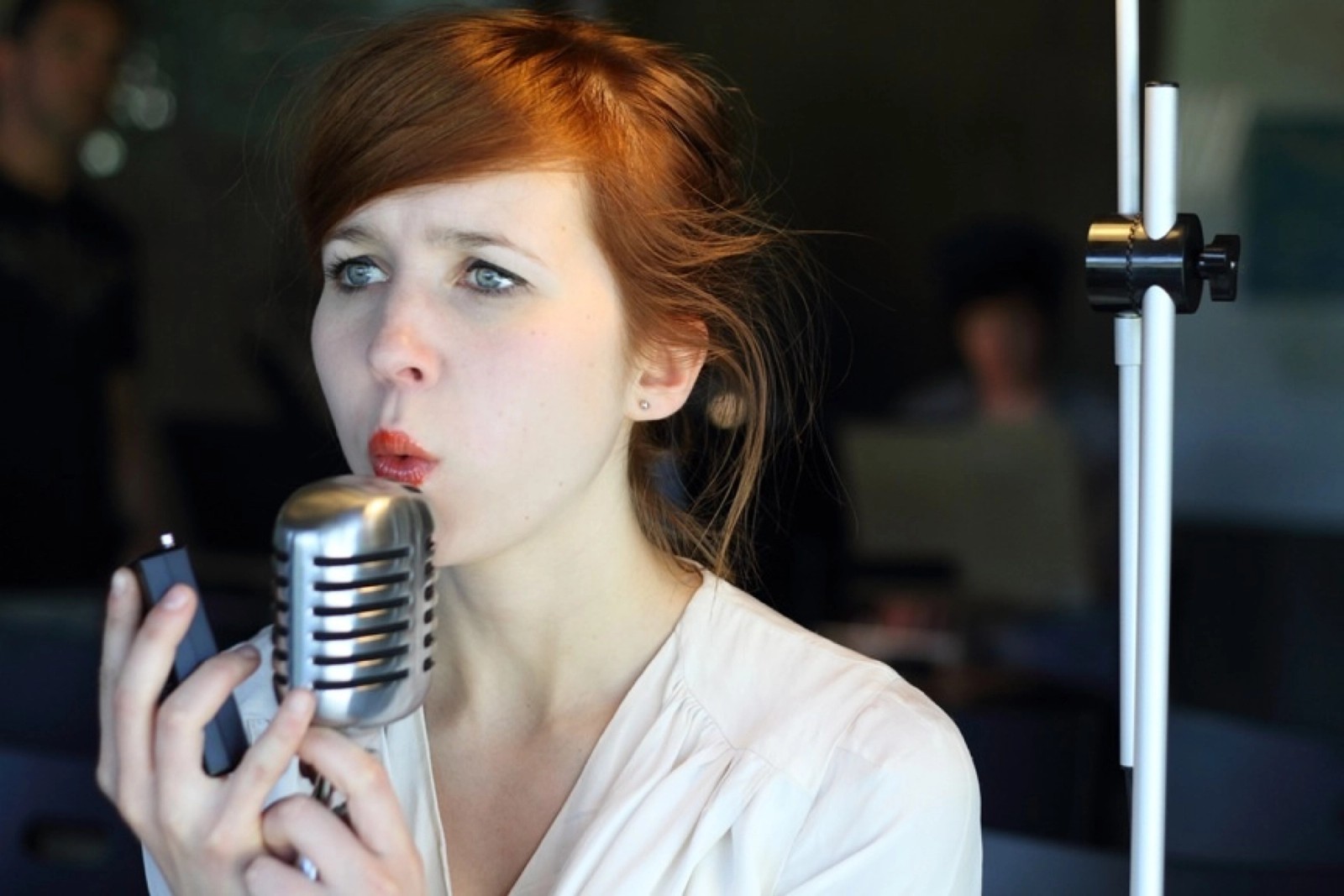 A woman singing into an old-fashioned microphone as part of Turbulence by Chamber Made