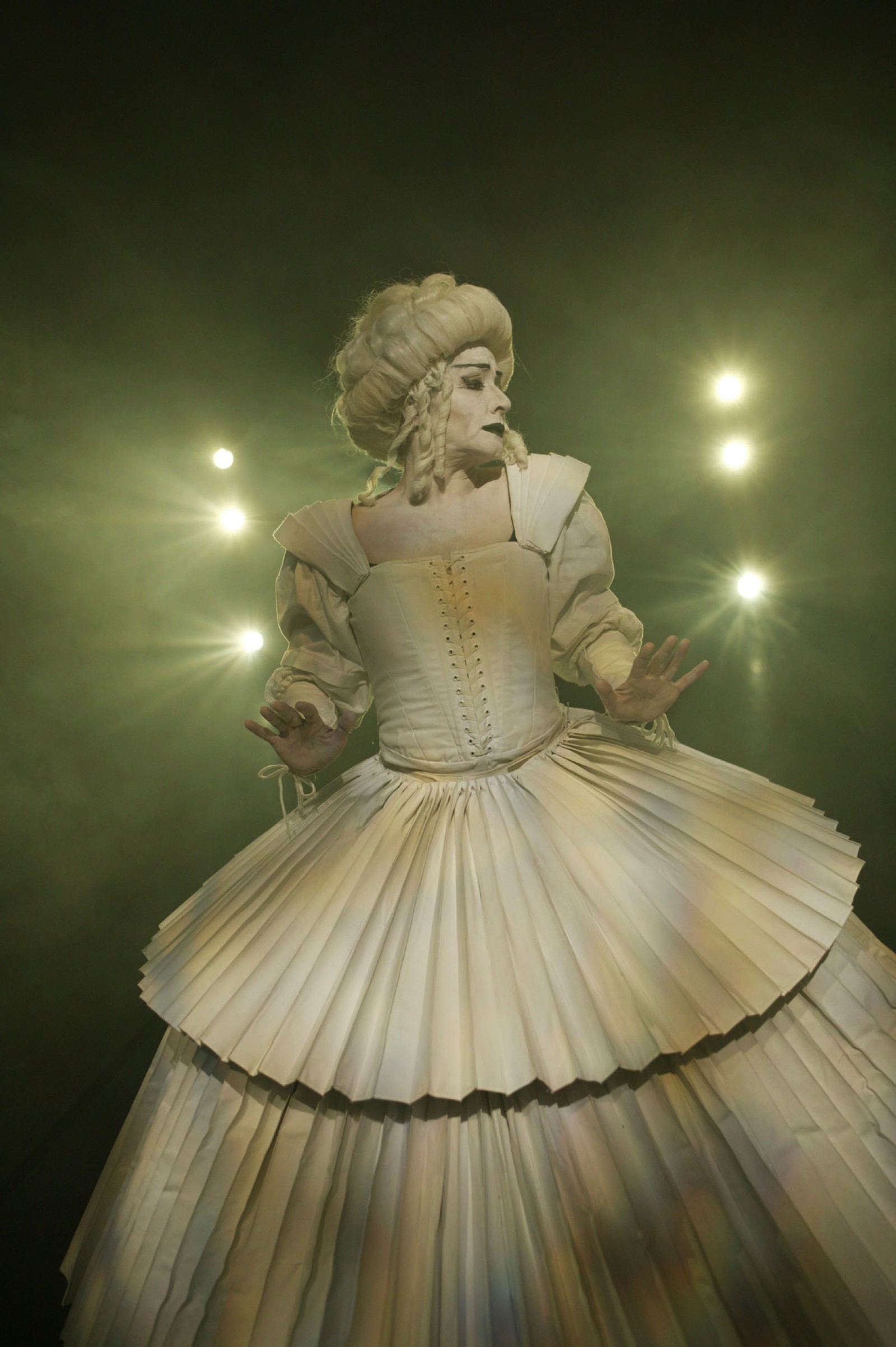 Woman in a white pleated gown with white baroque wig