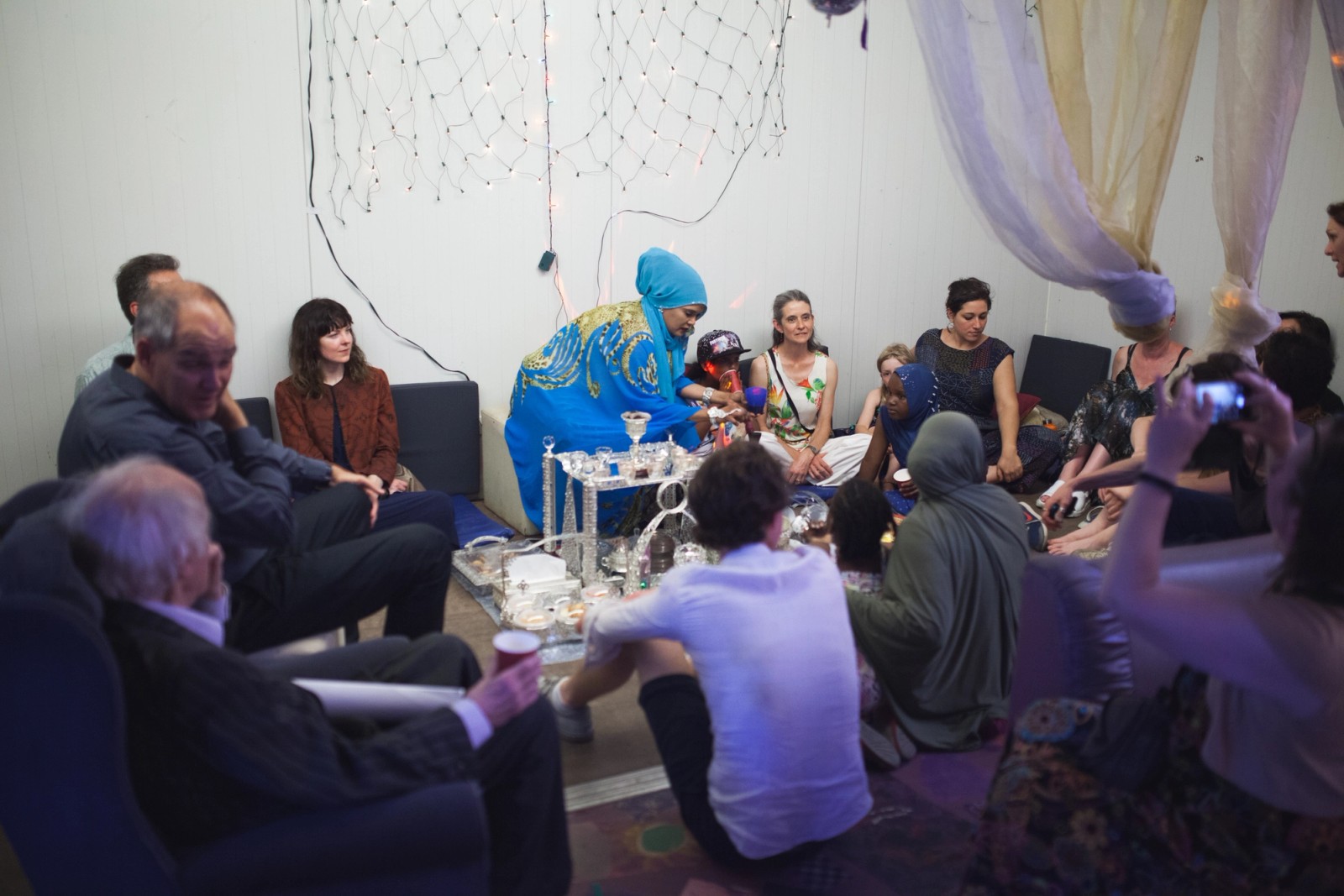 A woman conducts a coffee ceremony while others watch as part of The Chamber Made Venny Celebration 2018