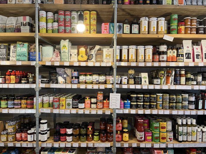 Shelves of jars, tins and packets from small makers on the pantry wall at Found Hope