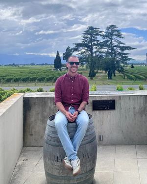 Tommaso Tadiello seduto davanti a un vigneto