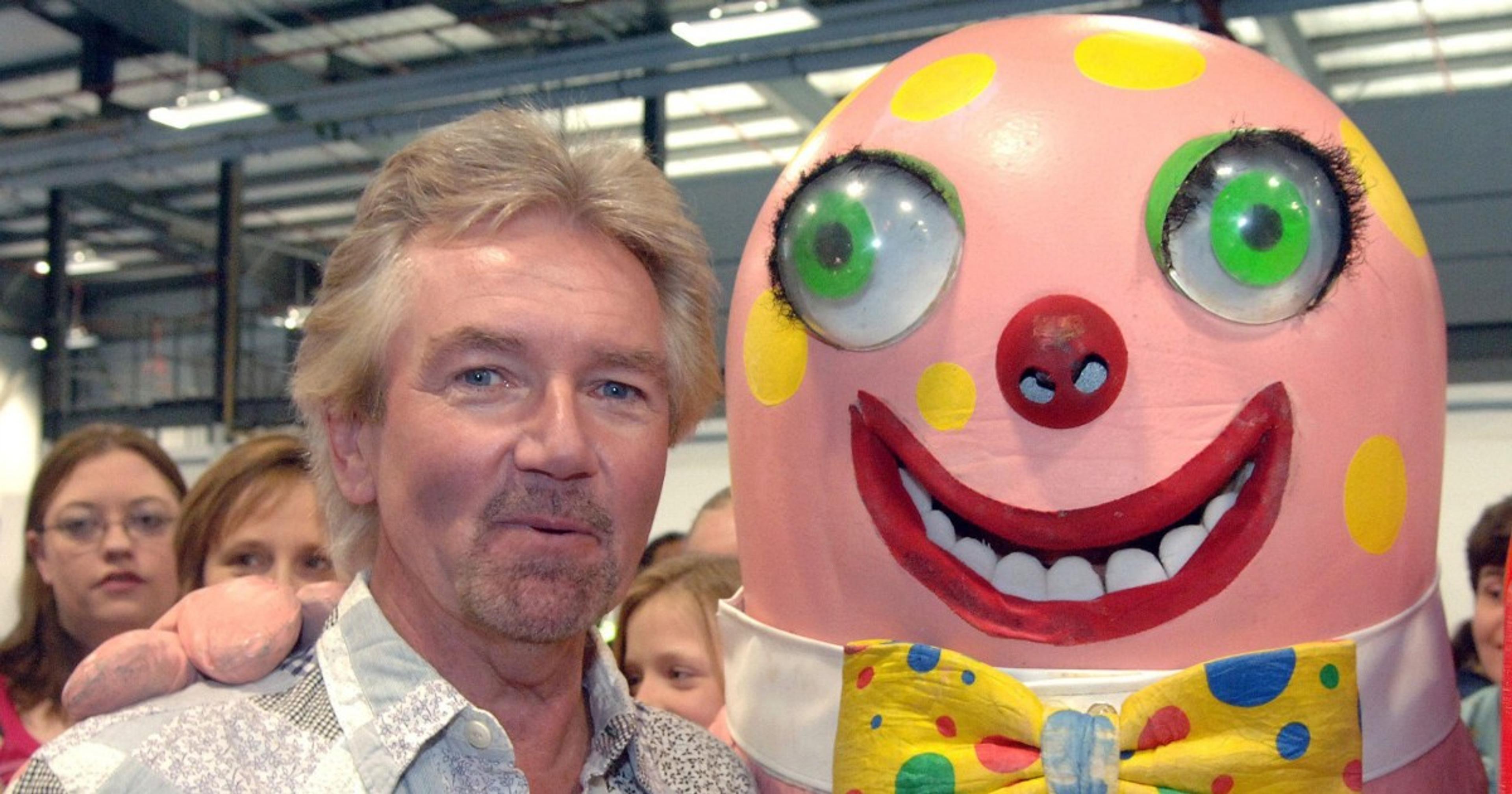 Pictured: a man with a round pink face, standing next to Mr Blobby