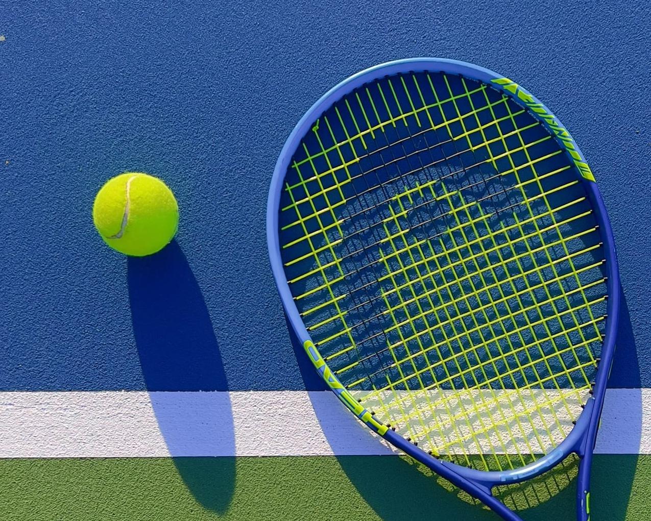 Racket and ball on a blue court